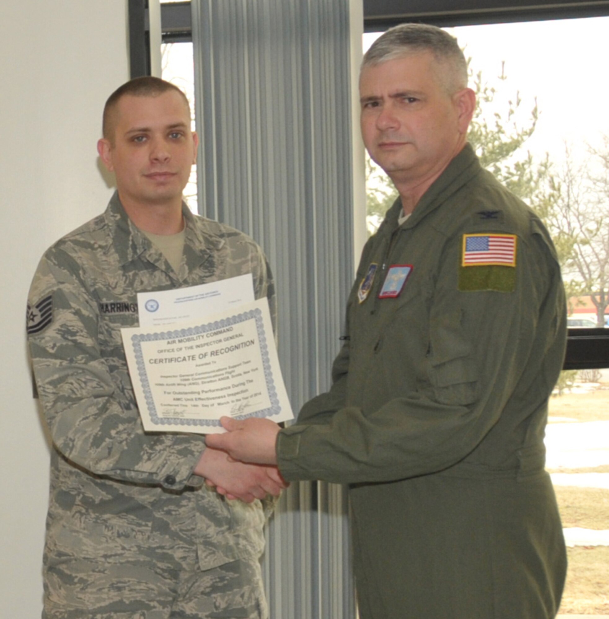 STRATTON AIR NATIONAL GUARD BASE, N.Y. -- Col. Shawn Clouthier (right), 109th Airlift Wing commander, presents Tech. Sgt. Robert Harrington with a certificate of recognition March 25, 2014, from Air Mobility Command for outstanding performance during the 109th AW's recent Unit Effectiveness Inspection. Harrington, of the 109th Communications Flight,was part of the Inspector General Communications Support Team, which received team recognition. Other members of the team not pictured were Master Sgt. Christopher Moore, Tech. Sgt. Jodi Habbinger, Tech. Sgt. Henry Smith, Senior Airman Matthew Almy, Airman 1st Class Collin Eustis, Airman 1st Class Joshua Speziale and Airman 1st Class Nicholas Tousignant. (Air National Guard photo by Master Sgt. William Gizara/Released)