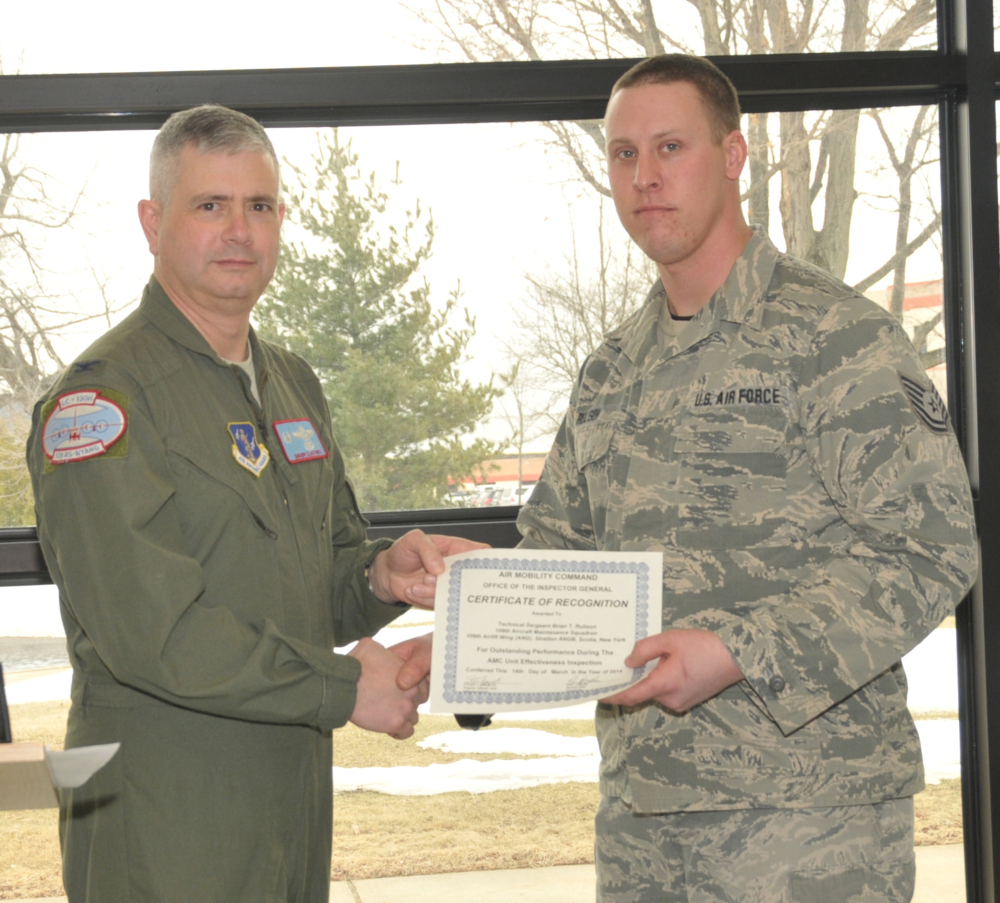 STRATTON AIR NATIONAL GUARD BASE, N.Y. -- Col. Shawn Clouthier (left), 109th Airlift Wing commander, presents Tech. Sgt. Brian Rulison with a certificate of recognition March 25, 2014, from Air Mobility Command for outstanding performance during the 109th AW's recent Unit Effectiveness Inspection. Rulison is assigned to the 109th Aircraft Maintenance Squadron. (Air National Guard photo by Master Sgt. William Gizara/Released)