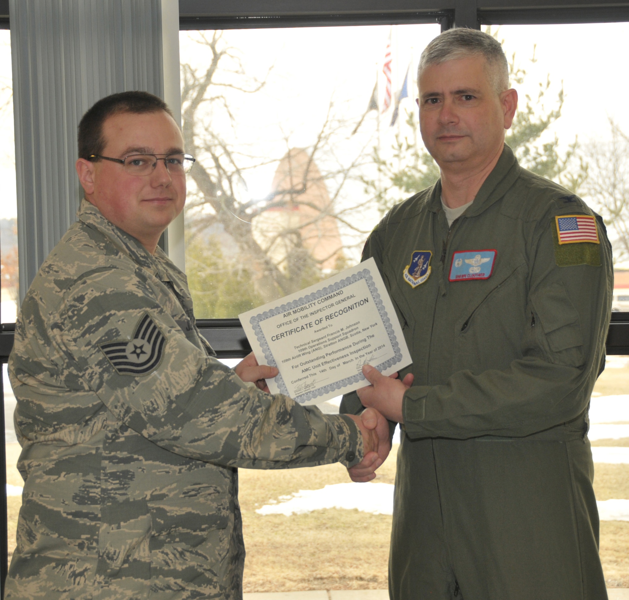 STRATTON AIR NATIONAL GUARD BASE -- Col. Shawn Clouthier (right), 109th Airlift Wing commander, presents Tech. Sgt. Francis Johnson with a certificate of recognition March 25, 2014, from Air Mobility Command for outstanding performance during the 109th AW's recent Unit Effectiveness Inspection. Johnson is assigned to the 109th Operations Support Squadron. (Air National Guard photo by Master Sgt. William Gizara/Released)