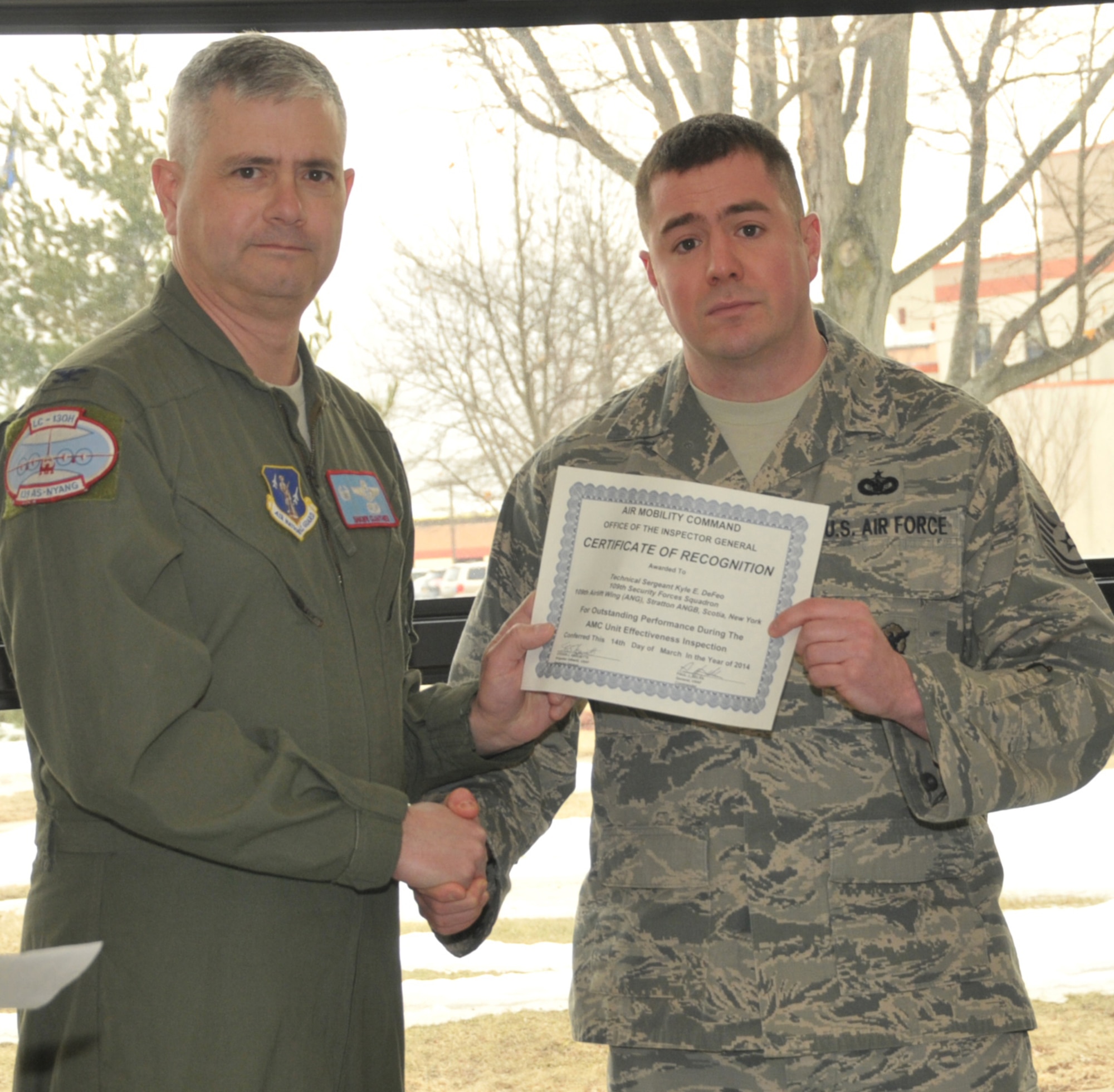 STRATTON AIR NATIONAL GUARD BASE -- Col. Shawn Clouthier (left), 109th Airlift Wing commander, presents Tech. Sgt. Kyle DeFeo with a certificate of recognition March 25, 2014, from Air Mobility Command for outstanding performance during the 109th AW's recent Unit Effectiveness Inspection. DeFeo is assigned to the 109th Security Forces Squadron. (Air National Guard photo by Master Sgt. William Gizara/Released)