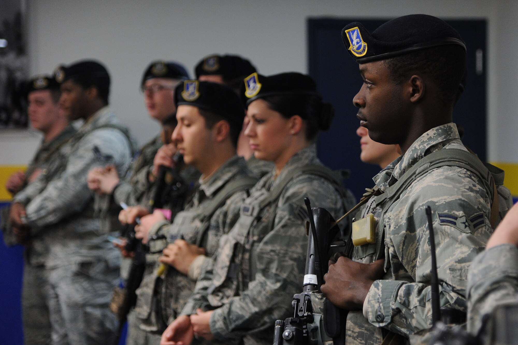 Airman 1st Class Danallen Lee, 341st Security Forces Squadron member (right), stands in formation during Guardmount March 25. Airmen stand in formation and are required to wear their approximately 30-pound flak vest – which carries all ammunition – as well as their weapon (if not assigned to heavy artillery), radio and beret for Guardmount. (U.S. Air Force photo/Senior Airman Cortney Paxton) 
