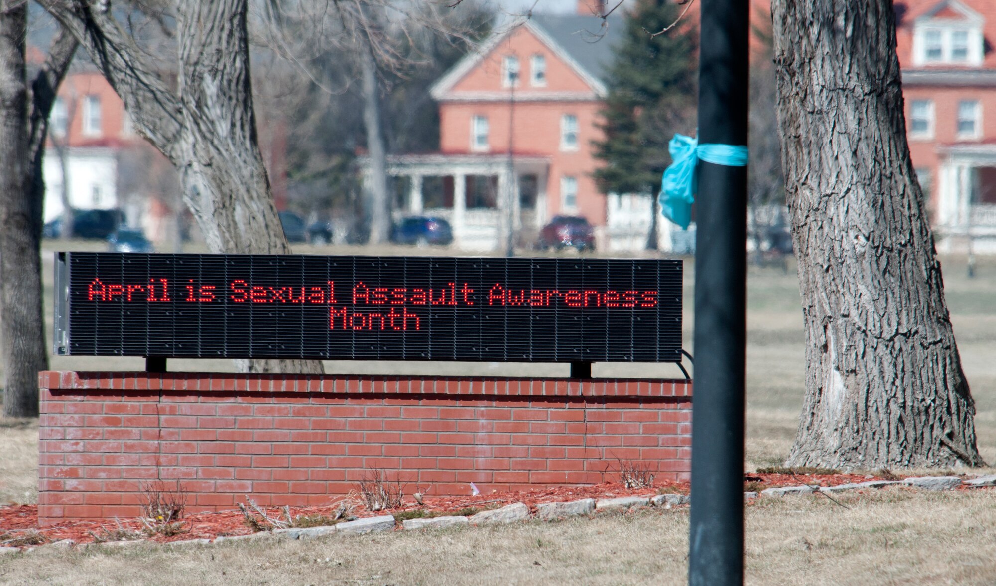 A teal bow tied on a light post in front of a marquee near Gate 1 represents sexual assault awareness month on F.E. Warren April 2, 2014. The Sexual Assault Prevention and Response Office  tied teal bows on light posts on Randall Avenue and placed teal covers over the flood lights shining on the missiles near Gate 1 to remind people to “Live Our Values: Step Up to Stop Sexual Assault.”  (U.S. Air Force photo by Airmen Malcolm Mayfield)