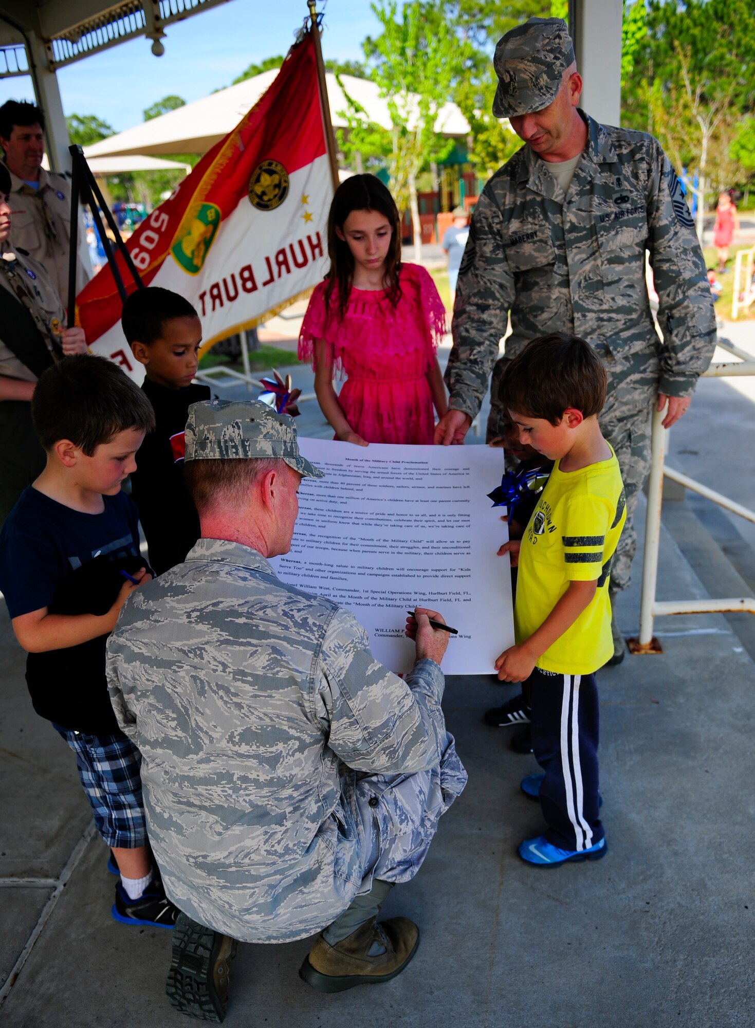 Col. William West, 1st Special Operations Wing commander, signs the proclamation designating April as the month of the military child at the community park on Hurlburt Field, Fla., April 2, 2014. Military children face many challenges such as moving frequently, changing schools, making new friends and deploying parents. (U.S. Air Force photo/Senior Airman Krystal M. Garrett)
