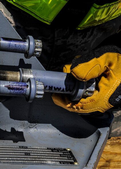 An Airman screws a bolt onto a brace during a unit effectiveness inspection at Moody Air Force Base, Ga., April 2, 2014. A team of Airmen from the 23d Equipment Maintenance Squadron used a ground instructor training aircraft to demonstrate the procedures for recovering a downed plane. (U.S. Air Force photo by Airman 1st Class Alexis Millican/Released)