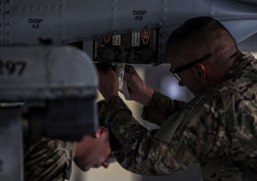 U.S. Air Force Tech. Sgt. Stanley Thompson, 23d Civil Engineer Squadron NCO in charge of explosive ordnance disposal (EOD) operations, secures a flare to an A-10C Thunderbolt II at Moody Air Force Base, Ga., April 1, 2014. Thompson was graded on his job performance during an EOD task evaluation. (U.S. Air Force photo by Airman 1st Class Alexis Millican/Released)