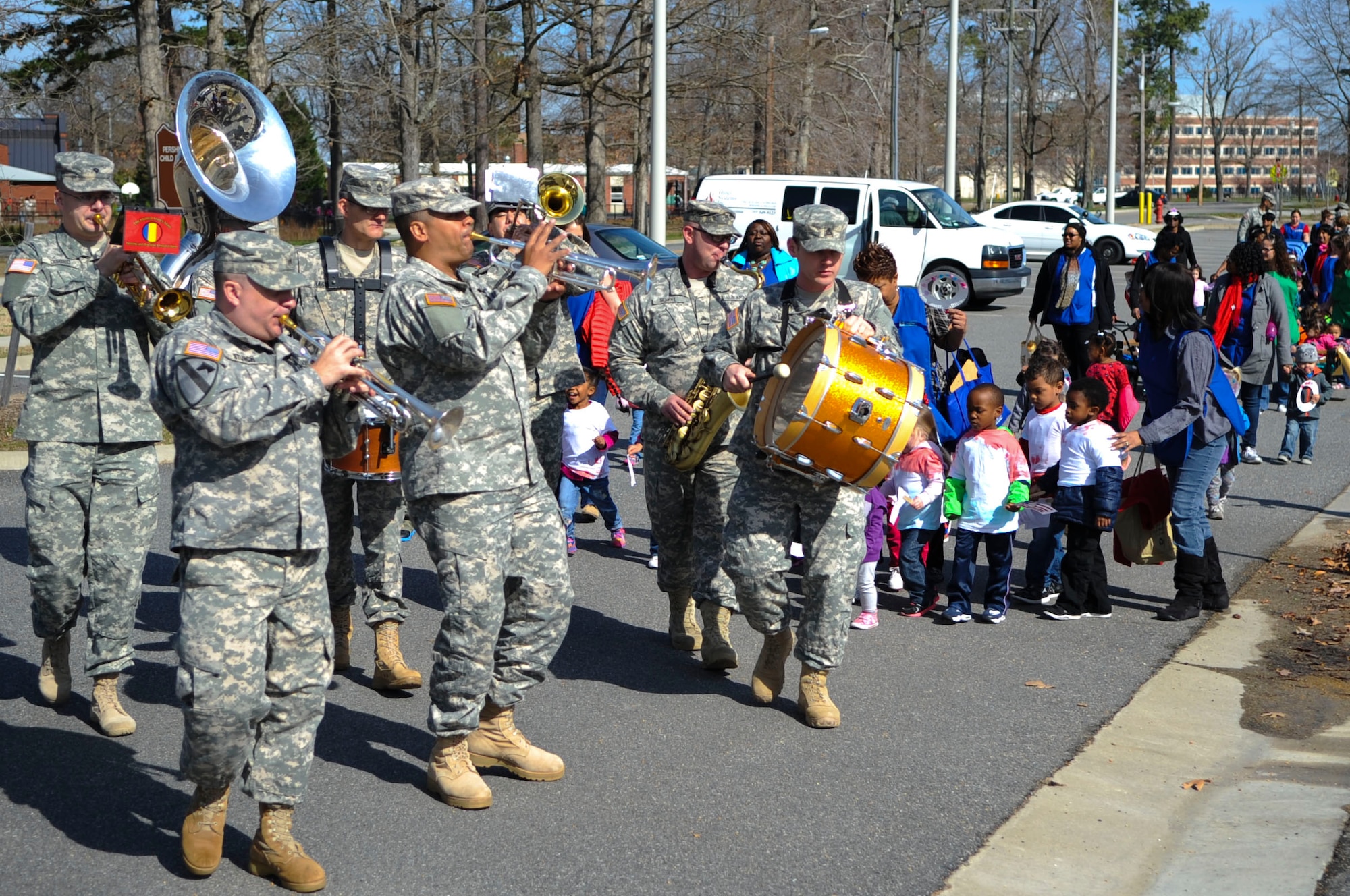 The U.S. Army Training and Doctrine Command band brass section leads Pershing Child Development Center children and personnel in song during a Month of the Military Child march at Fort Eustis, Va., April 1, 2014. During April, Joint Base Langley-Eustis Child and Youth Services providers will host different events to highlight military children for their sacrifices. (U.S. Air Force photo by Senior Airman Austin Harvill/Released) 