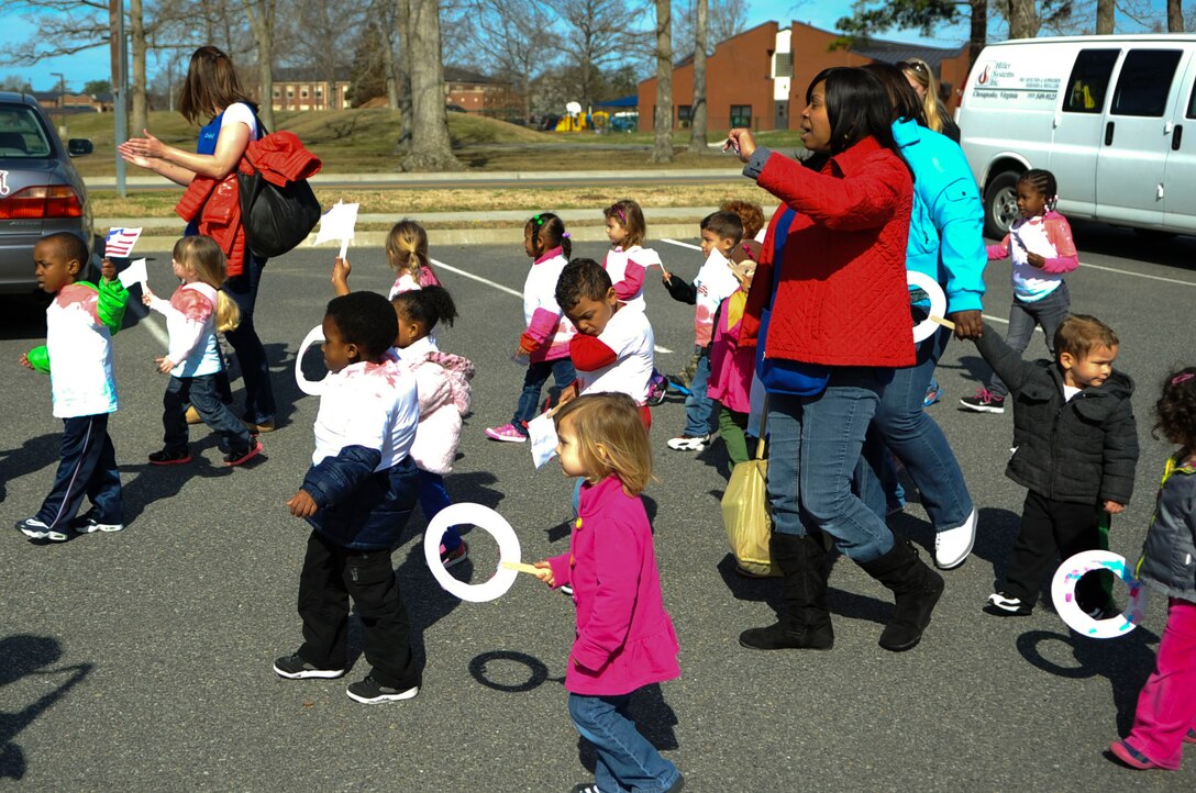 Pershing Child Development Center children and personnel participate in a Month of the Military Child march at Fort Eustis, Va., April 1, 2014. The U.S. Army Training and Doctrine Command band brass section played marching music during the event. (U.S. Air Force photo by Senior Airman Austin Harvill/Released) 