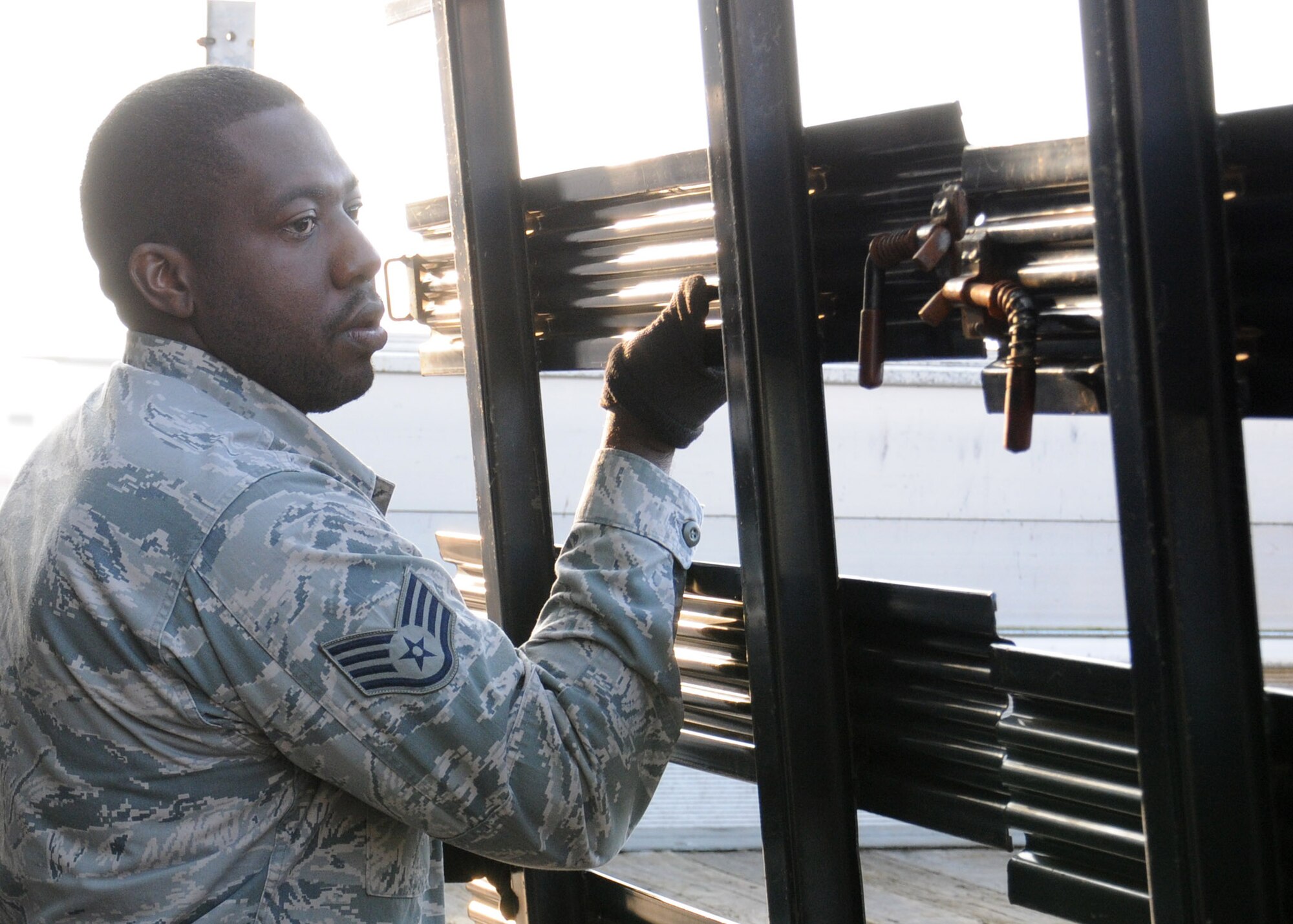 U.S. Air Force Staff Sgt. Kevon McCadney, 100th Logistics Readiness Squadron Aircraft Parts Store supervisor from Detroit, removes side panels from a government-owned vehicle prior to loading April 1, 2014, on RAF Mildenhall, England. The shop manages $82 million worth of parts, which it stores and delivers to Team Mildenhall upon request. (U.S. Air Force photo by Gina Randall/Released)