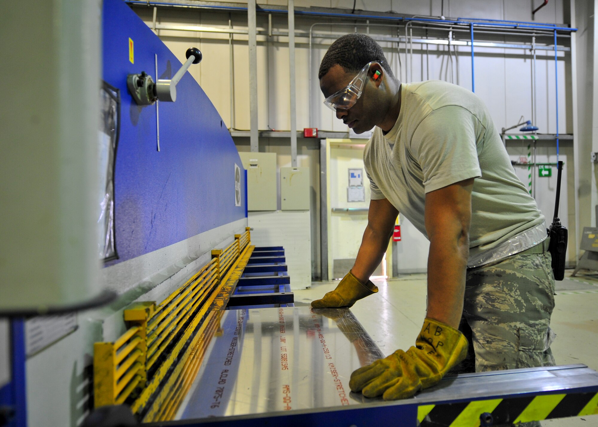 Air Force Staff Sgt. Christopher Jackson, 380th Expeditionary Maintenance Squadron Aircraft Structural Maintenance craftsman, uses a power sheer to cut a peice of sheet metal at an undisclosed location in Southwest Asia, April 1, 2014. Jackson is a native of Atlanta, Ga. and is deployed from Tinker Air Force Base Okla. (U.S. Air Force photo by Staff Sgt. Michael Means/Released)