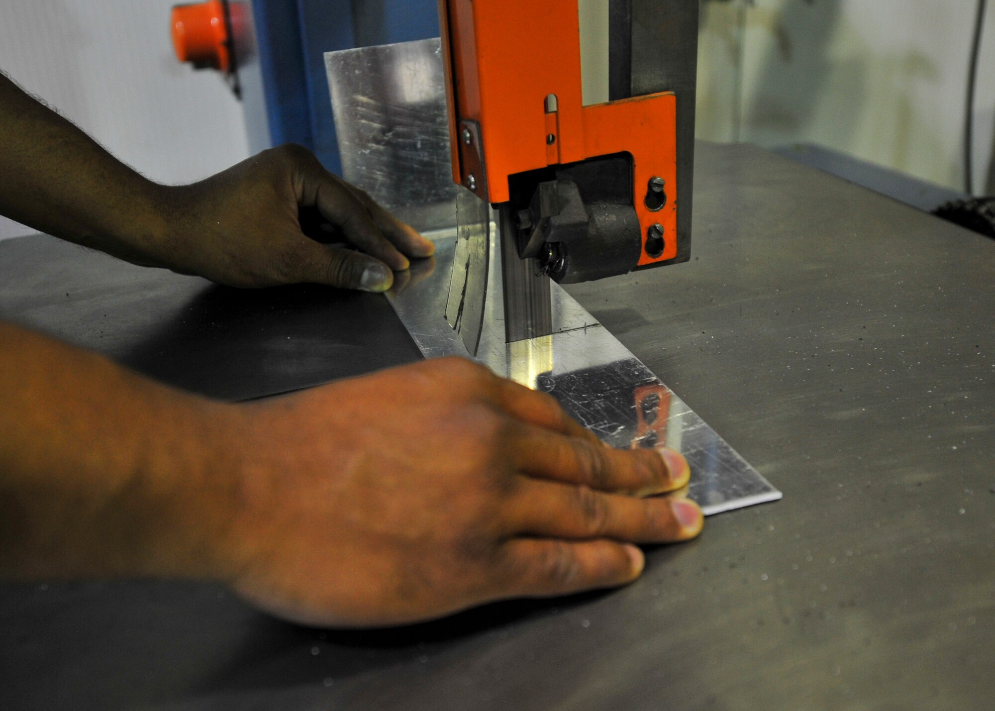Air Force Staff Sgt. Christopher Jackson, 380th Expeditionary Maintenance Squadron Aircraft Structural Maintenance craftsman, uses a bandsaw to fabricate an aircraft part at an undisclosed location in Southwest Asia, April 1, 2014. Jackson is a native of Atlanta, Ga. and is deployed from Tinker Air Force Base Okla. (U.S. Air Force photo by Staff Sgt. Michael Means/Released)