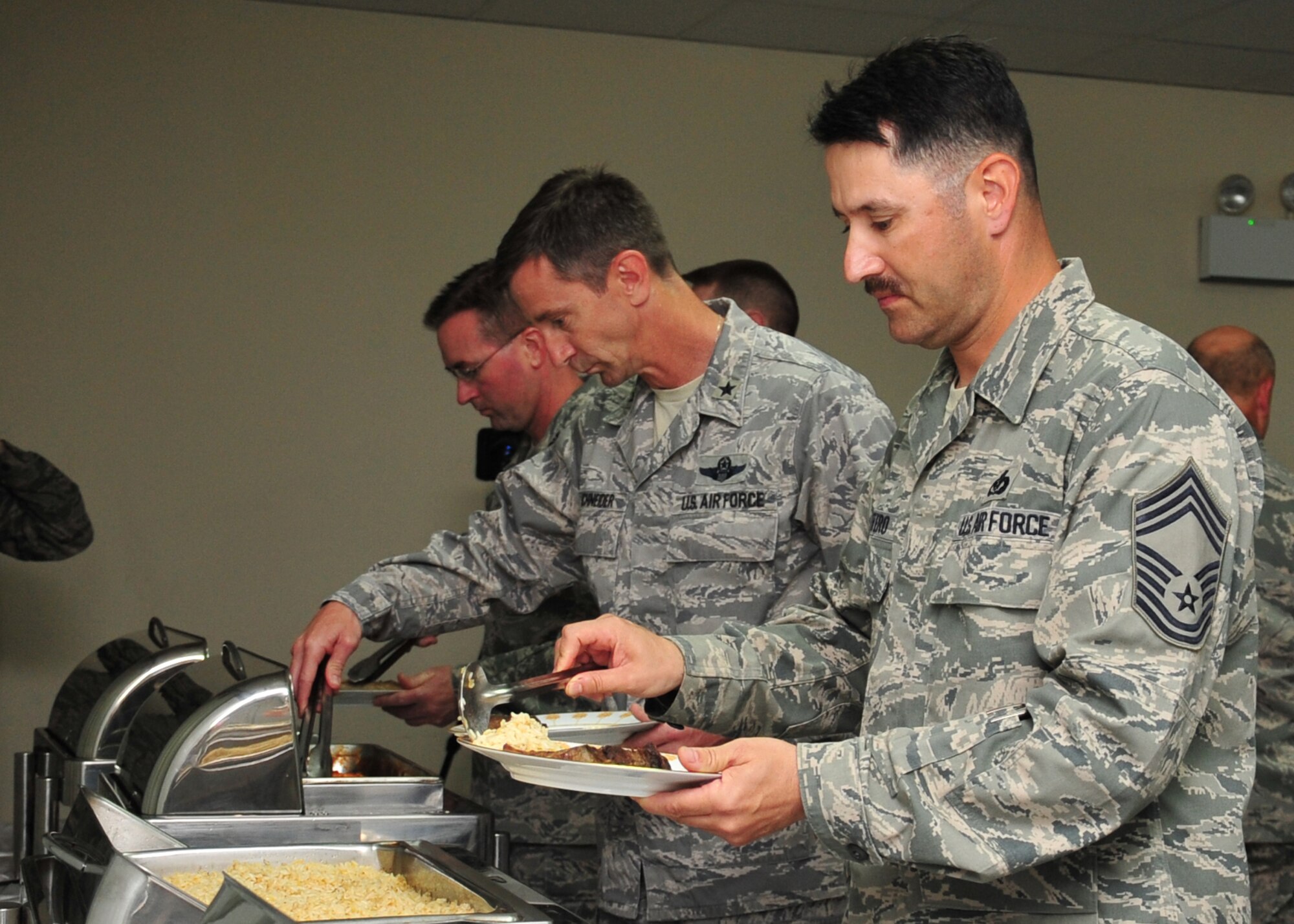 Airmen of the 380th Expeditionary Wing go through the buffet provided by the 380th Expeditionary Force Support Squadron Oasis dining facility staff during the Chief's induction ceremony at an undisclosed location in Southwest Asia, March 29, 2014. (U.S. Air Force photo by Staff Sgt. Michael Means/Released)
