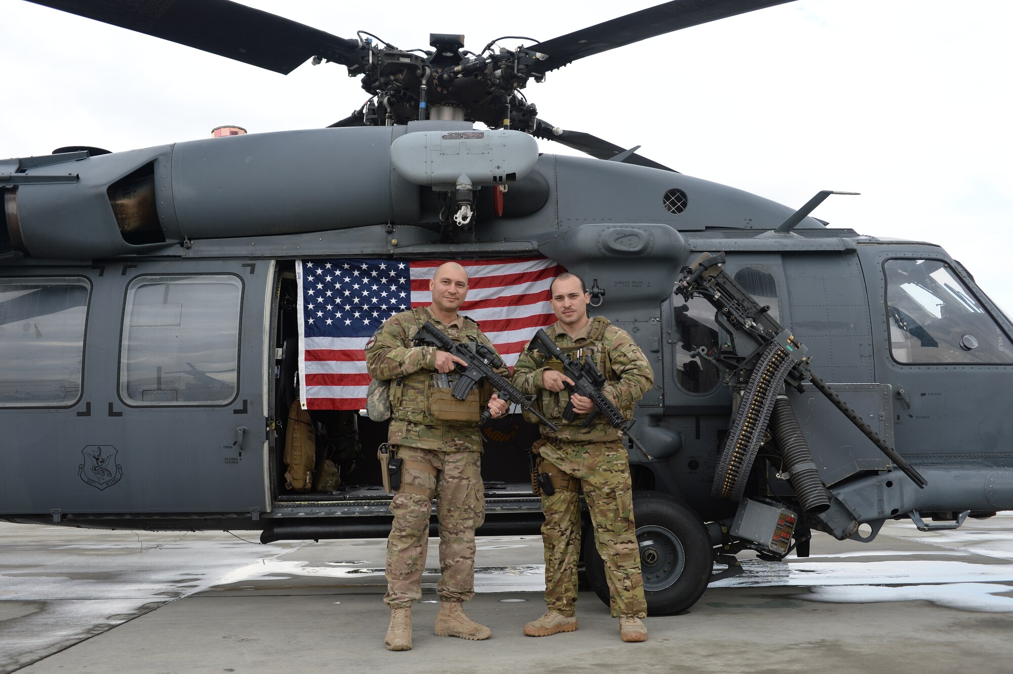 U.S. Air Force Staff Sgt. Jean Vega Martinez, 83rd Expeditionary Rescue Squadron flight engineer and his father, U.S. Air Force Senior Master Sgt. Carmelo Vega Martinez, 438th Air Expeditionary Wing/NATO Air Training Command-Afghanistan recruiting adviser, pose in front of an HH-60 Pave Hawk helicopter after Staff Sgt. Vega Martinez re-enlistment ceremony, March 17, 2014, Bagram Air Field, Afghanistan. Prior to the ceremony, father and son, both Ponce, Puerto Rico natives, hadnt seen each other in two years due to military commitments.  The two are deployed at separate Operation Enduring Freedom bases, 40 miles across the combat zone.  The two are deployed at separate Operation Enduring Freedom bases, 40 miles across the combat zone.  (U.S. Air Force photo by Tech. Sgt. Jason Robertson/Released)