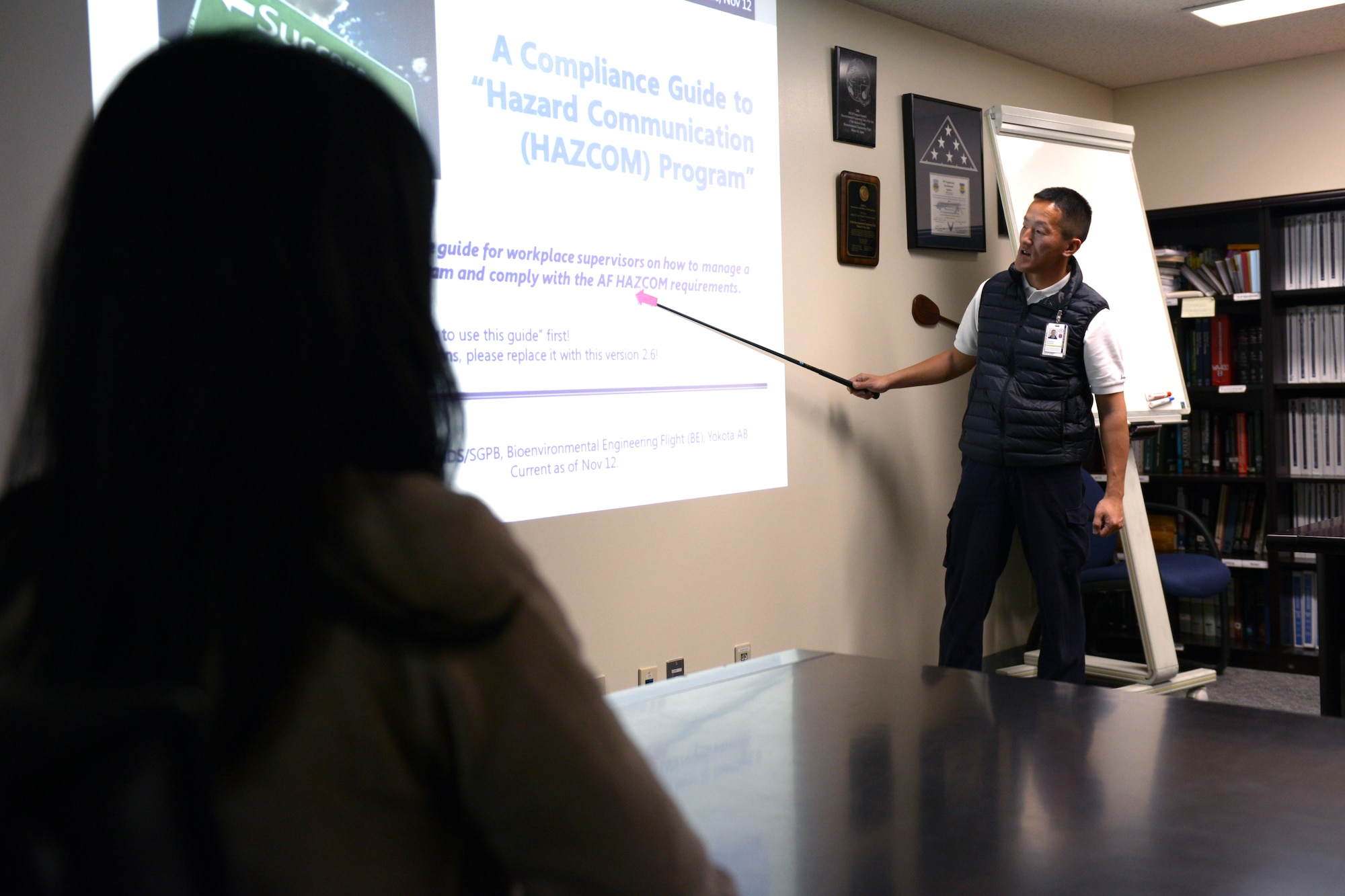 Masuhiro Shinozaki, 374th Aerospace Medicine Squadron bioenvironmental technician, briefs Mariko Mogi, 374th Aerospace Medicine Squadron environmental program manager, on hazard communication at Yokota Air Base, Japan, April 1, 2014. The briefings are held to ensure that both service members and civilian employees are aware and in compliance with Air Force hazard communication requirements. (U.S. Air Force photo by Airman 1st Class David Danford/Released)