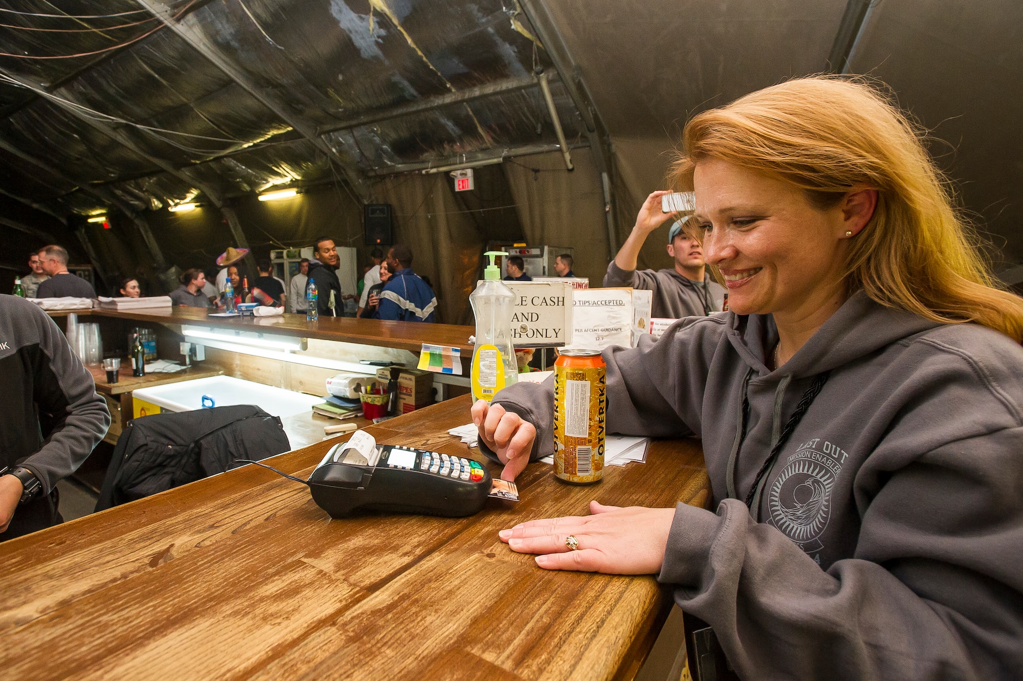 Col. Tammy Hinkston, 376th Expeditionary Force Support Squadron commander, pays for the last drink sold at Pete's Place at Transit Center at Manas, Kyrgyzstan, March 31, 2014. Pete's Place was a centralized recreation center for transients and permanent party members to socialize and build morale. Pete’s Place was named after Peter J. Ganci Jr., a New York City fire chief who lost his life on Sept. 11, 2001. (U.S. Air Force photo/Senior Airman George Goslin)

