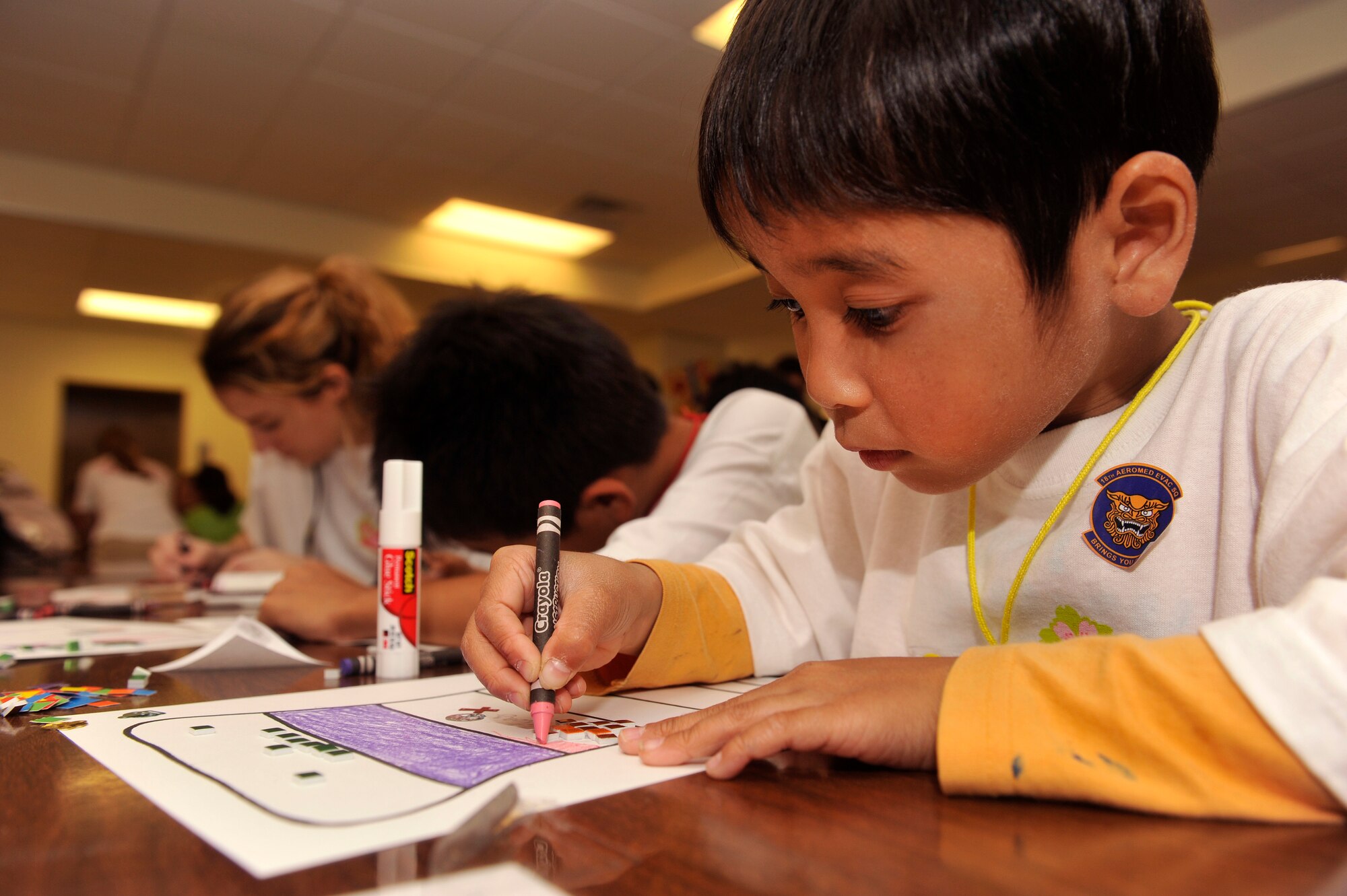 A child from an Okinawan foster home, colors at Amelia Earhart Intermediate School during Operation Sakura on Kadena Air Base, Japan, March 28, 2014. The children from the Okinawan orphanages were divided into eight groups and toured different squadrons and facilities to learn about the base and mission of the 18th Wing. (U.S. Air Force photo by Naoto Anazawa)