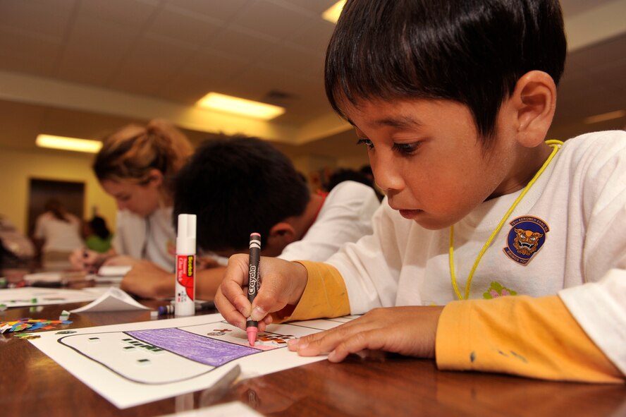 A child from an Okinawan foster home, colors at Amelia Earhart Intermediate School during Operation Sakura on Kadena Air Base, Japan, March 28, 2014. The children from the Okinawan orphanages were divided into eight groups and toured different squadrons and facilities to learn about the base and mission of the 18th Wing. (U.S. Air Force photo by Naoto Anazawa)
