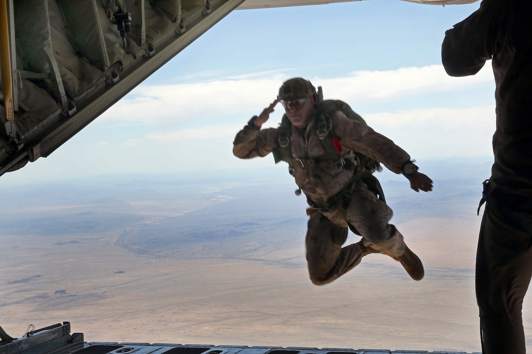 Marine Corps Master Sgt. Randy Messineo salutes the crew of a C-130 ...