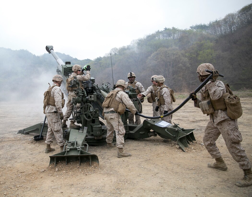 Lance Cpl. Aaron Manigault holds the rammer to push a round into an M777A2 lightweight 155 mm howitzers April 3 at Su Seung-ri Range in the Republic of Korea as part of Exercise Ssang Yong 2014. The Marines shot off eight rounds during the calibration portion of the live-fire, followed by another 40 rounds in succession. Ssang Yong is an exercise that showcases the amphibious and expeditionary capabilities of the ROK and U.S. forces as well as the maturity of the relationship between the two nations. Manigault, a native of New York City, is a field artillery cannoneer with Golf Battery, 2nd Battalion, 11th Marine Regiment currently assigned to Battalion Landing Team 2nd Bn., 5th Marines, 31st Marine Expeditionary Unit, III Marine Expeditionary Force. (U.S. Marine Corps photo by Cpl. Lena Wakayama/Released)