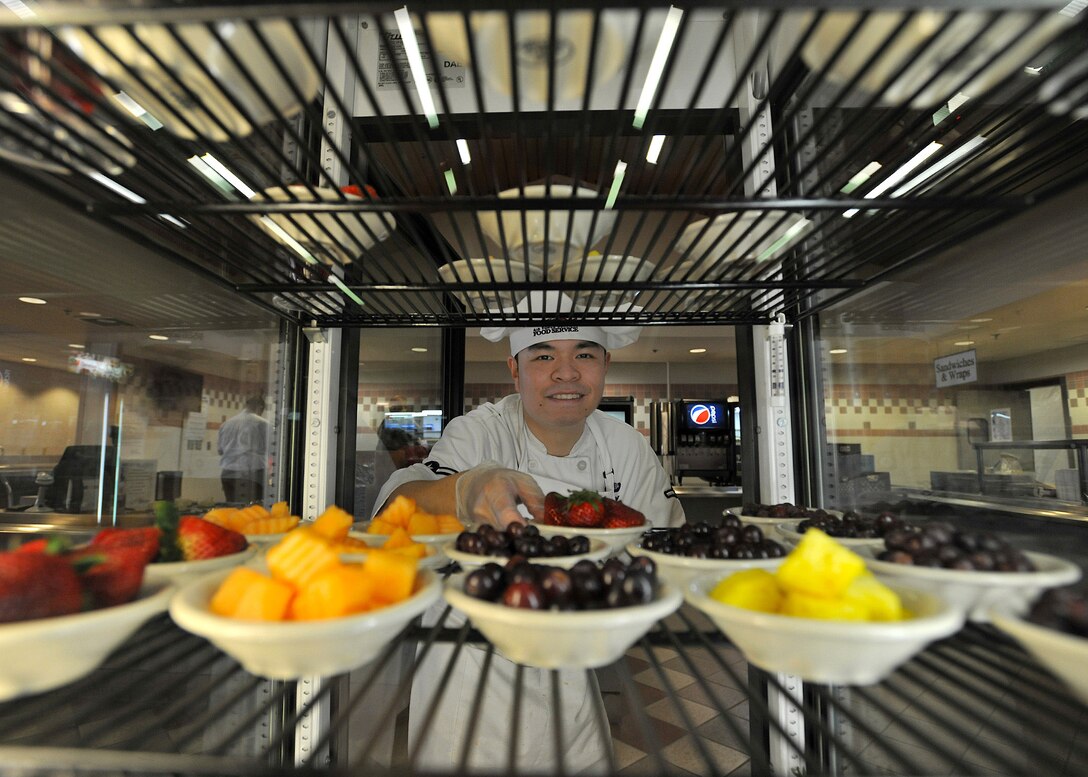 Airman Robbie Day restocks the dessert fridge with fruit March 20, 2014, at the Airey Dining Facility on Grand Forks Air Force Base, N.D. Day emigrated from China with his family when he was 19. He recently became a U.S. citizen and plans on becoming a registered nurse and commissioning as an Air Force medical officer. Day is a 319th Force Support Squadron food service apprentice. (U.S. Air Force photo/Senior Airman Xavier Navarro)