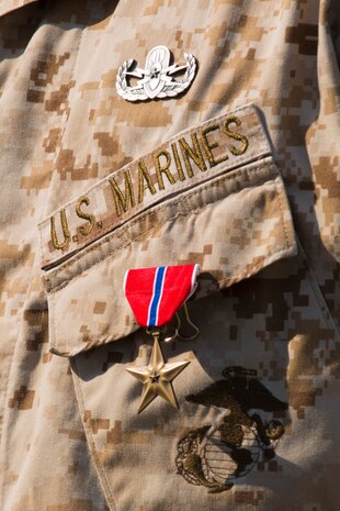 Staff Sgt. Brandon R. Trent, a Lawrence, Kan., native and explosive ordnance disposal technician with 2nd EOD Company, 8th Engineer Support Battalion, 2nd Marine Logistics Group, wears the Bronze Star Medal during a ceremony aboard Camp Lejeune, N.C., April 4, 2014. Trent earned the medal with combat distinguishing device for his actions disarming improvised explosive devices while deployed in support of Operation Enduring Freedom in 2013. In a period of less than 24 hours, Trent rendered nine improvised explosive devices safe during a clearing operation in Helmand province, Afghanistan. Trent worked into the night, uncovering and disarming additional IEDs along the way. He manually approached and disarmed two of the IEDs after exhausting remote deactivation methods. (U.S. Marine Corps photo by Cpl. Shawn Valosin)