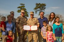 Brigadier General Edward D. Banta (left center), the commanding general of the 2nd Marine Logistics Group, poses for a photo with Staff Sgt. Brandon R. Trent (right), a Lawrence, Kan. Native, and explosive ordnance disposal technician with 2nd EOD Company, 8th Engineer Support Battalion, 2nd MLG, and his family after a Bronze Star Medal award ceremony aboard Camp Lejeune, N.C., April 4, 2014. Trent earned the medal with combat distinguishing device for his actions disarming improvised explosive devices while deployed in support of Operation Enduring Freedom in 2013. In a period of less than 24 hours, Trent rendered nine improvised explosive devices safe during a clearing operation in Helmand province, Afghanistan. Trent worked into the night, uncovering and disarming additional IEDs along the way. He manually approached and disarmed two of the IEDs after exhausting remote deactivation methods.