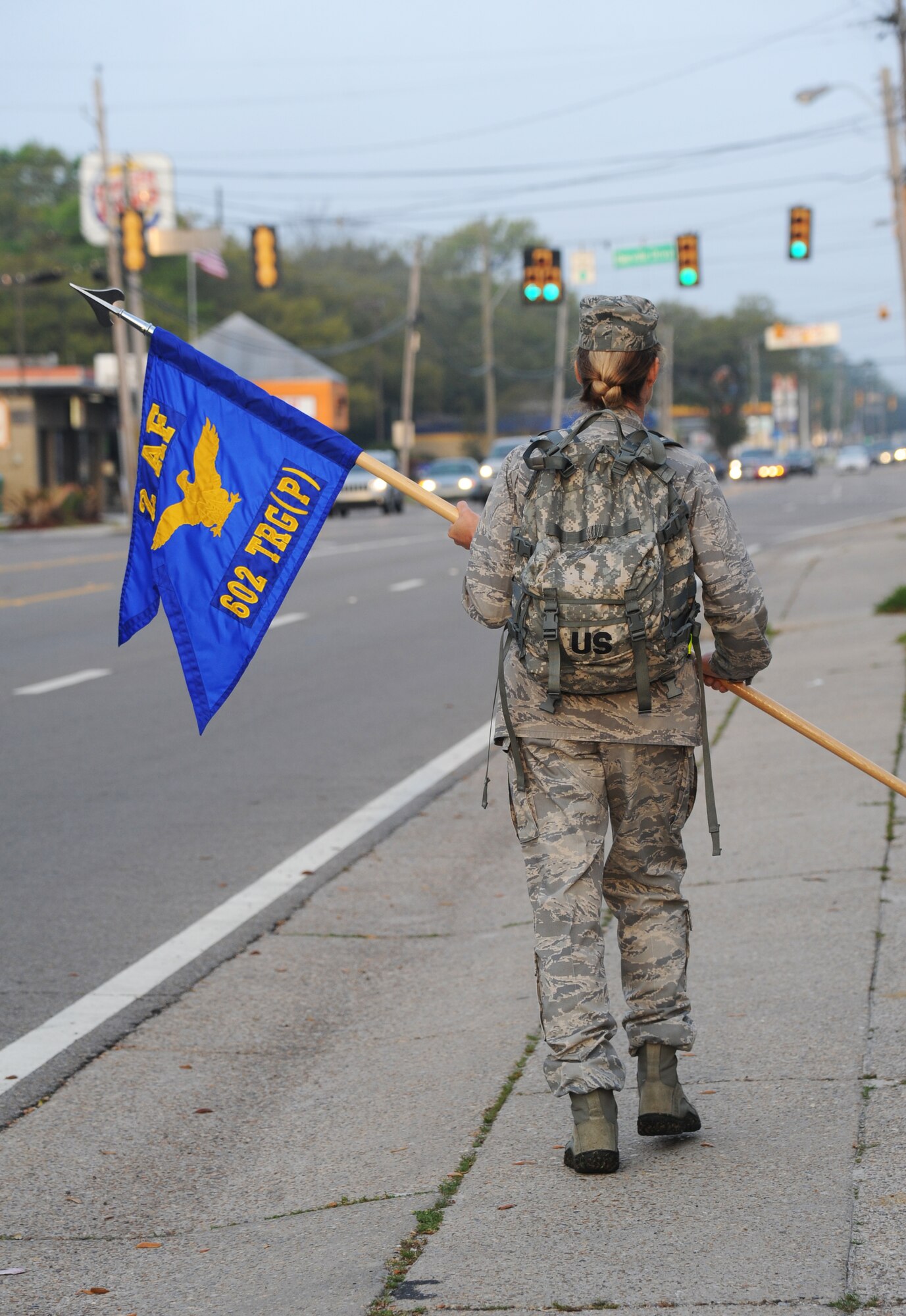 Col. Melanie Milburn carries a guidon and ruck sack down Pass Road as she participates in an 84-mile ruck march April 2, 2014, Biloxi, Miss. The three day march which starts here and ends at Camp Shelby Army Post, Miss., is meant to commemorate the 602nd TRG (P) mission in support of joint expeditionary tasking’s and to remember the students who made the ultimate sacrifice. Milburn is the 602nd Training Group (Provisional) commander. (U.S. Air Force photo/Kemberly Groue)