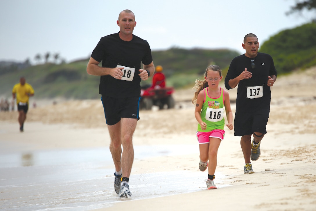 Robert Harrison (left), a Marine with 1st Battalion, 12th Marine Regiment runs with his daughter Zoie, 8, during the annual Surf & Turf 5k run March 29, 2014, aboard Marine Corps Base Hawaii. (U.S. Marine Corps photo by Cpl. Sarah Dietz)

