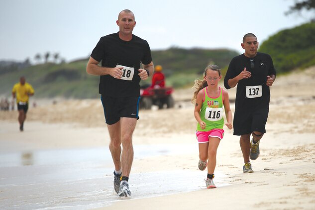 Robert Harrison (left), a Marine with 1st Battalion, 12th Marine Regiment runs with his daughter Zoie, 8, during the annual Surf & Turf 5k run March 29, 2014, aboard Marine Corps Base Hawaii. (U.S. Marine Corps photo by Cpl. Sarah Dietz)

