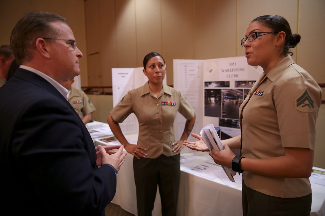 Cpl. Caitlyn Cowen explains to Steven Kowalski, a representative of Merrill Lynch, what she and her co-worker, Cpl. Sarah Escudero, have to offer the civilian workforce during the Hiring America's Heroes symposium held at Camp Pendleton, April 4. Cowen and Escudero are warehouse clerks with 1st Supply Battalion, Combat Logistics Regiment 15, 1st Marine Logistics Group.