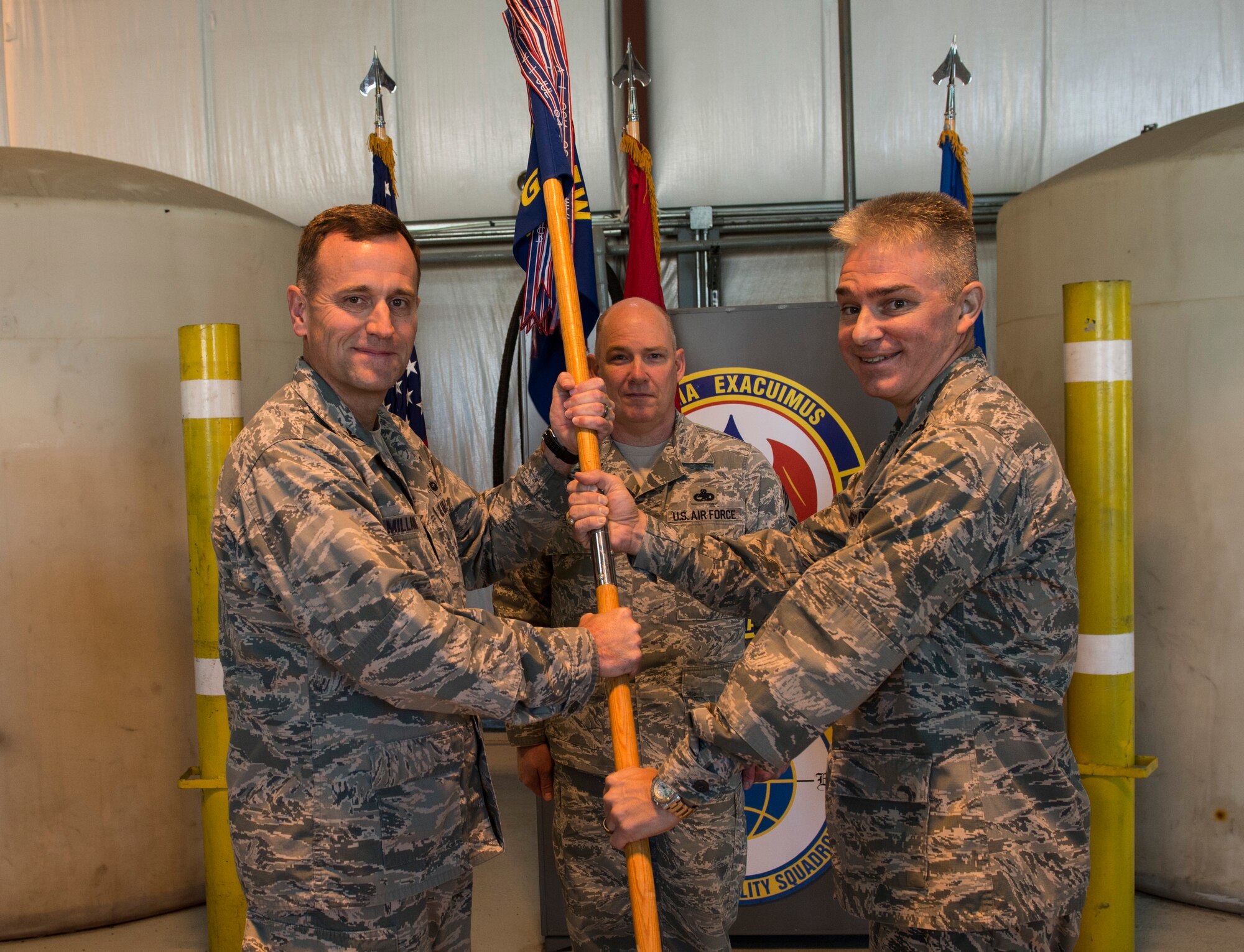 Col. John C. Millard, 376th Air Expeditionary Wing commander, receives the guidon from Col. Stanly Springer, 376th Expeditionary Maintenance Group commander, April 2, 2014, signifying a relinquished command and thereby allowing the squadron to be inactivated at Transit Center at Manas, Kyrgyzstan.  After 12 years of keeping aircraft flying and Airmen in the fight, the maintenance group and squadron will both stay inactivated until called upon to serve again. (U.S. Air Force photo/Staff Sgt. Travis Edwards)