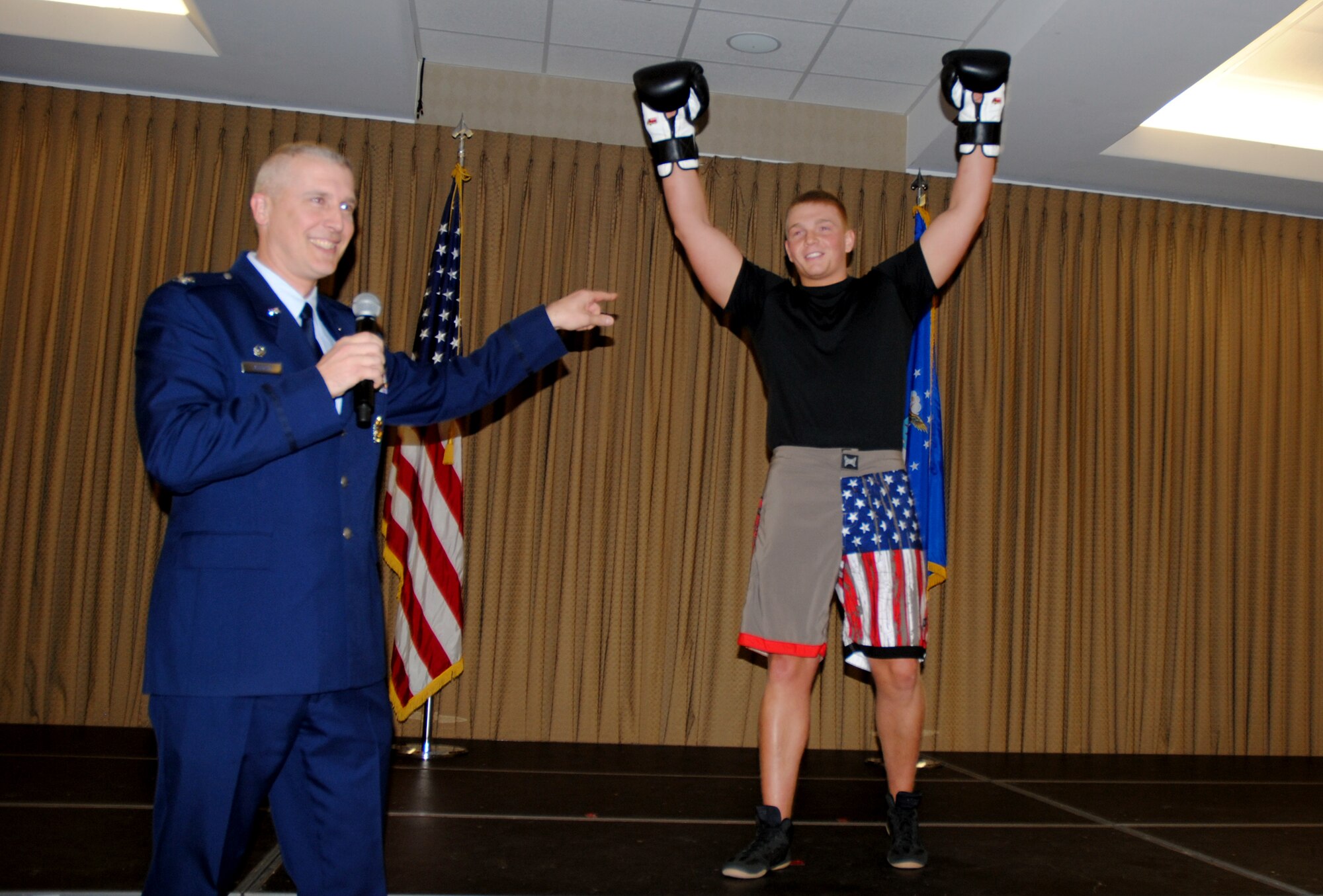 Col. Paul Bauman, 319th Air Base Wing commander, points to Airman 1st Class Sean Egan from the 319th Security Forces Squadron during the final portion of a promotions ceremony held April 2, 2014, at the Northern Lights Club at Grand Forks Air Force Base N.D. Eagan will be one of three Airmen competing in Boxing Nite. The 319th Force Support Squadron is scheduled to host Boxing Nite on April 12, 2014, at the 3-Bay Hangar on Grand Forks Air Force Base, N.D. (U.S. Air Force photo/Staff Sgt. Luis Loza Gutierrez)