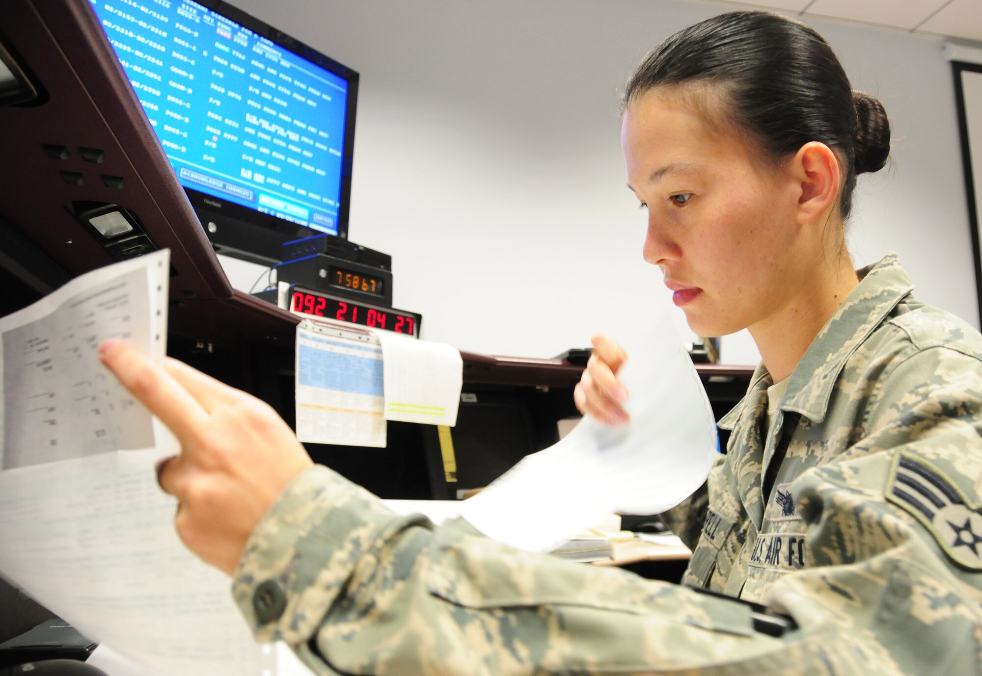 Air Force Reserve Senior Airman Anne-Marie Mandrell, 6th Space Operations Squadron, reviews the day's coding instructions for a weather satellite April 3, 2014 at Schriever Air Force Base, Colo. The squadron's satellite vehicle operators assumed command of the nation's Defense Meteorological Satellite Program weather satellites from their National Oceanic and Atmospheric Administration counterparts as the nation's newest weather satellite lifted into orbit aboard an Atlas V rocket at Vandenberg AFB, Calif. The squadron will oversee all weather satellite operations until April 8. Mandrell is a 6th SOPS satellite vehicle operator. (U.S. Air Force photo/Tech. Sgt. Stephen J. Collier)