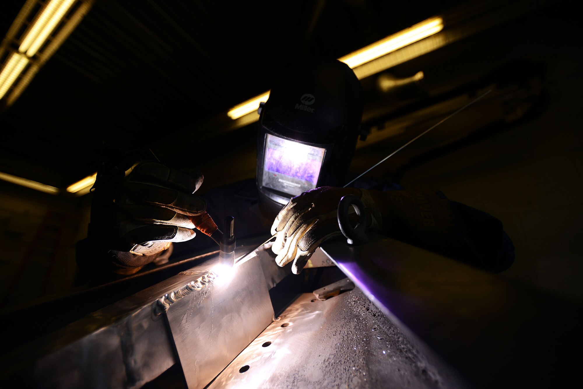 U.S. Air Force Senior Airman Matthew Neale, 20th Equipment Maintenance Squadron metals technologist journeyman, welds a metal plate onto a toe bar, Shaw Air Force Base, S.C., April 2, 2014. When tungsten inert gas welding, Neale holds the aluminum rod on the surface of the metal while simultaneously holding the electric torch approximately one fourth of an inch away from the aluminum to create an electric arc which melts the aluminum. Airmen who work in the 20th EMS metals technology shop use their welding skill set to support the 20th Maintenance Group which maintains the 20th Fighter Wing’s 88 F-16CJ Fighting Falcons. (U.S. Air Force photo by Airman 1st Class Jensen Stidham/Released)