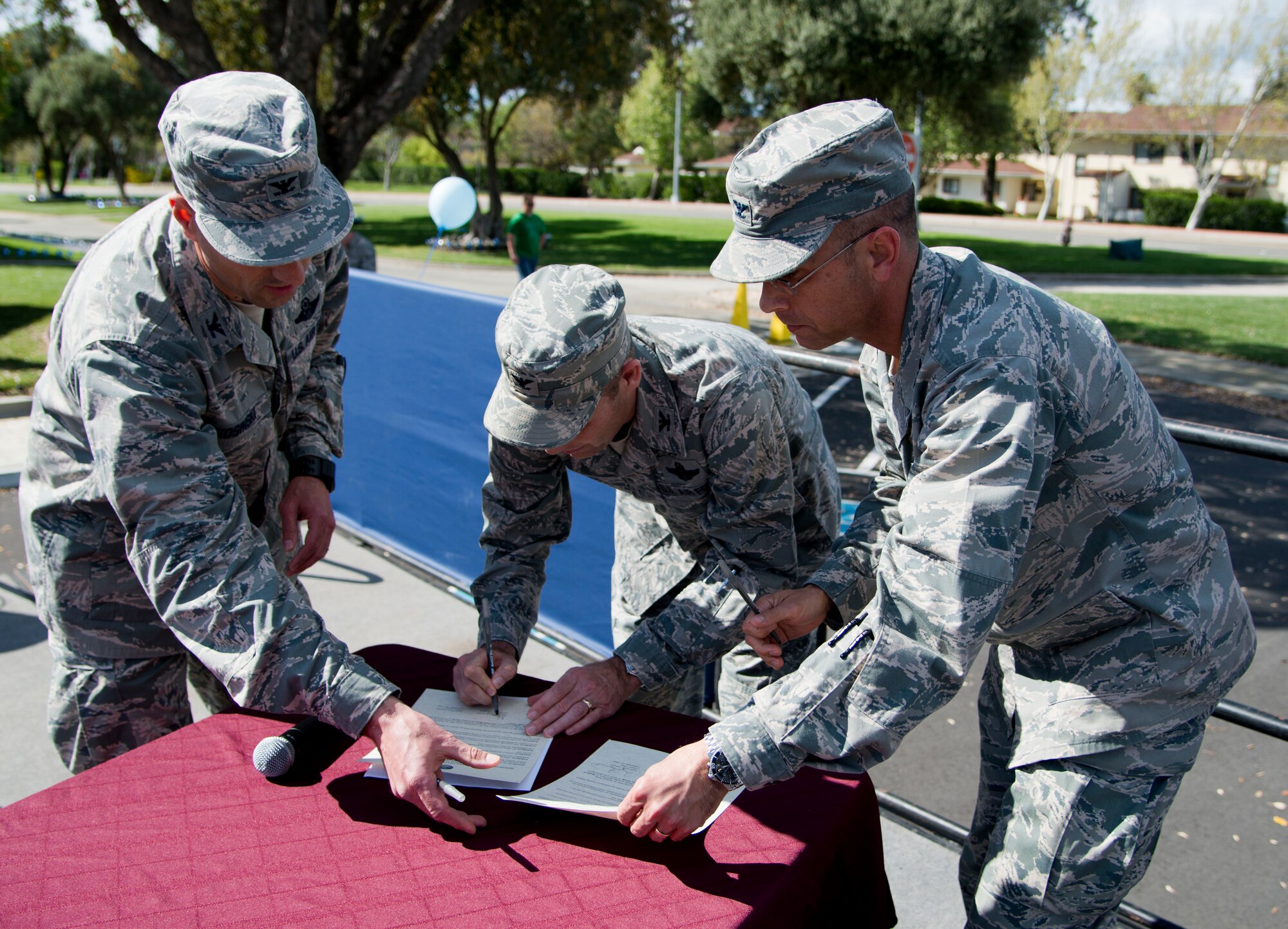 Col. Leonard Kosinski, 60th Air Mobility Wing vice commander, Col. Matthew Burger, 349th AMW commander, and Col. Mark MacDonald, 615th Contingency Operations Support Group commander and stand –in 615th Contingency Response Wing commander, sign the Month of the Military Child Proclamation at the Airman and Family Readiness Center during Family Fun Fest Wednesday. The proclamations paid tribute to military children, acknowledging their commitment, support and sacrifices as their parents serve in the armed services. (U.S. Air Force photo/Senior Airman Nicole Leidholm)