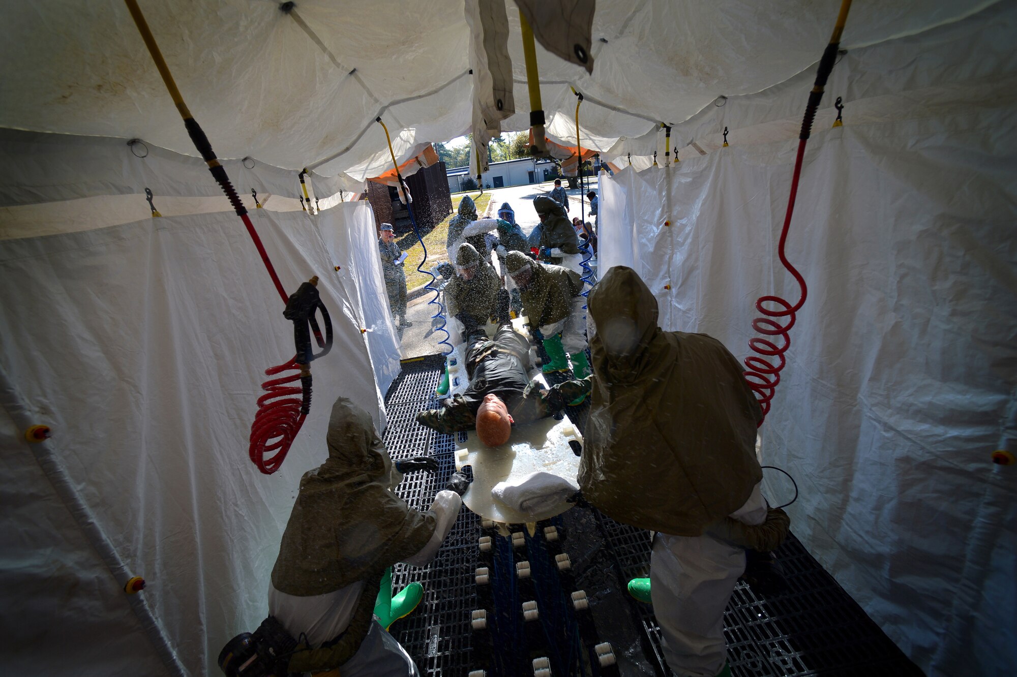 U. S. Air Force Airmen assigned to the 20th Medical Group work together to decontaminate Staff Sgt. James Springer, 20th Medical Operations Squadron alcohol, drug, abuse, prevention, and treatment NCO in charge during a Mass Accident Response Exercise, April 4, 2014, Shaw Air Force Base, S.C. Springer was affected by simulated chemical and biological agents. The 20th MDG holds exercises such as these during different times of the year to stay trained and prepared for real world situations. (U.S. Air Force photo by Staff Sgt. Kenny Holston/Released)