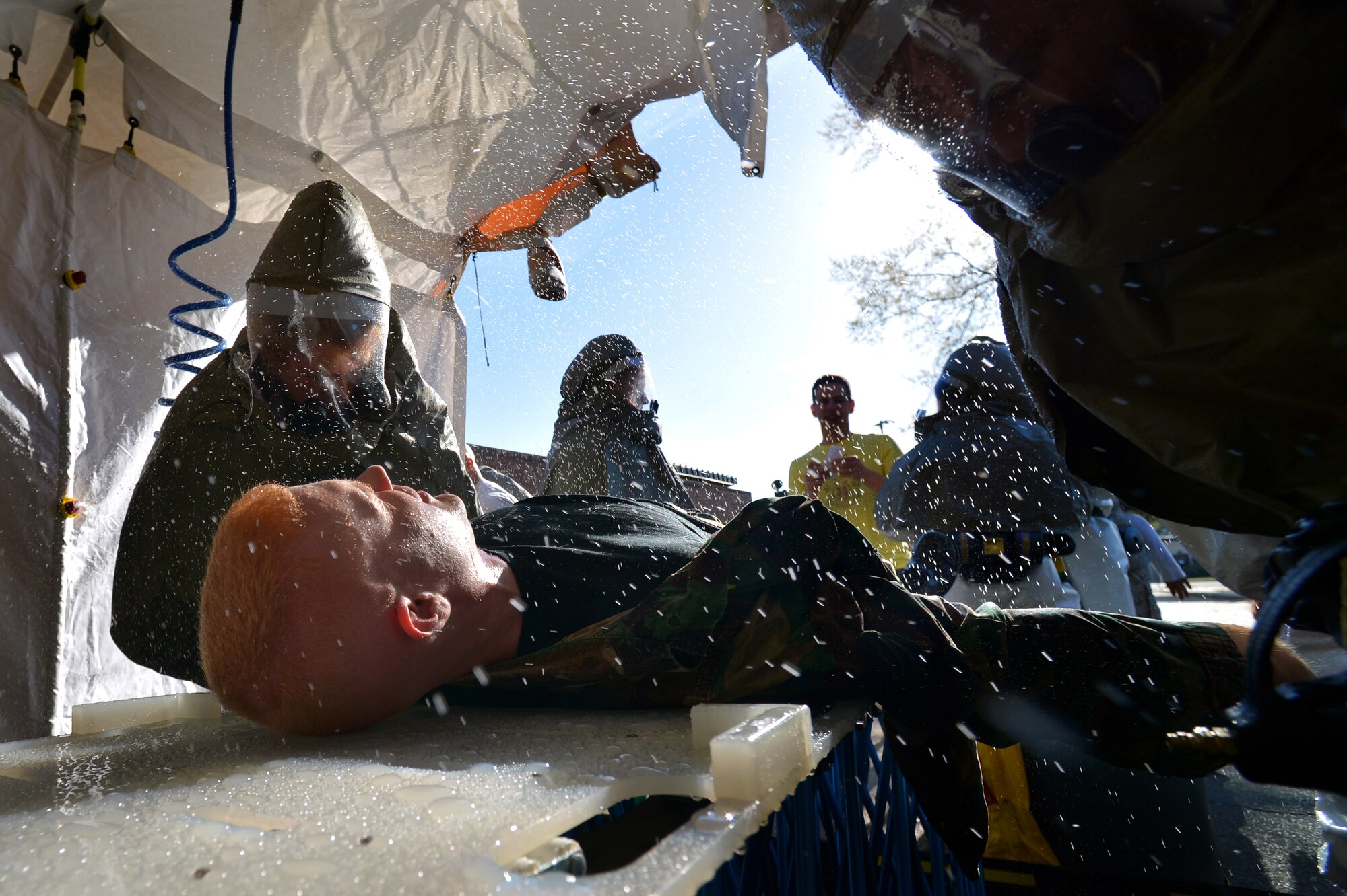 U.S. Air Force Staff Sgt. James Springer, 20th Medical Operations Squadron alcohol, drug, abuse, prevention, and treatment NCO in charge, (center,) is sprayed with water while being decontaminated during a Mass Accident Response Exercise, April 4, 2014, Shaw Air Force Base, S.C. The 20th MDG holds exercises such as these during different times throughout the year to stay trained and prepared for real world situations. (U.S. Air Force photo by Staff Sgt. Kenny Holston/Released)