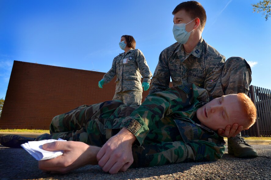 U. S. Air Force Capt. Justin Slager, 20th Dental Squadron aids Staff Sgt. James Springer, 20th Medical Operations Squadron while Tech Sgt. Jennifer Barlow, 20th Dental Squadron seeks further assistance during a Mass Accident Response Exercise, April 4, 2014, Shaw Air Force Base, S.C. Springer was affected by simulated chemical and biological agents. The 20th MDG holds exercises such as these during different times throughout the year to stay trained and prepared for real world situations. (U.S. Air Force photo by Staff Sgt. Kenny Holston/Released)