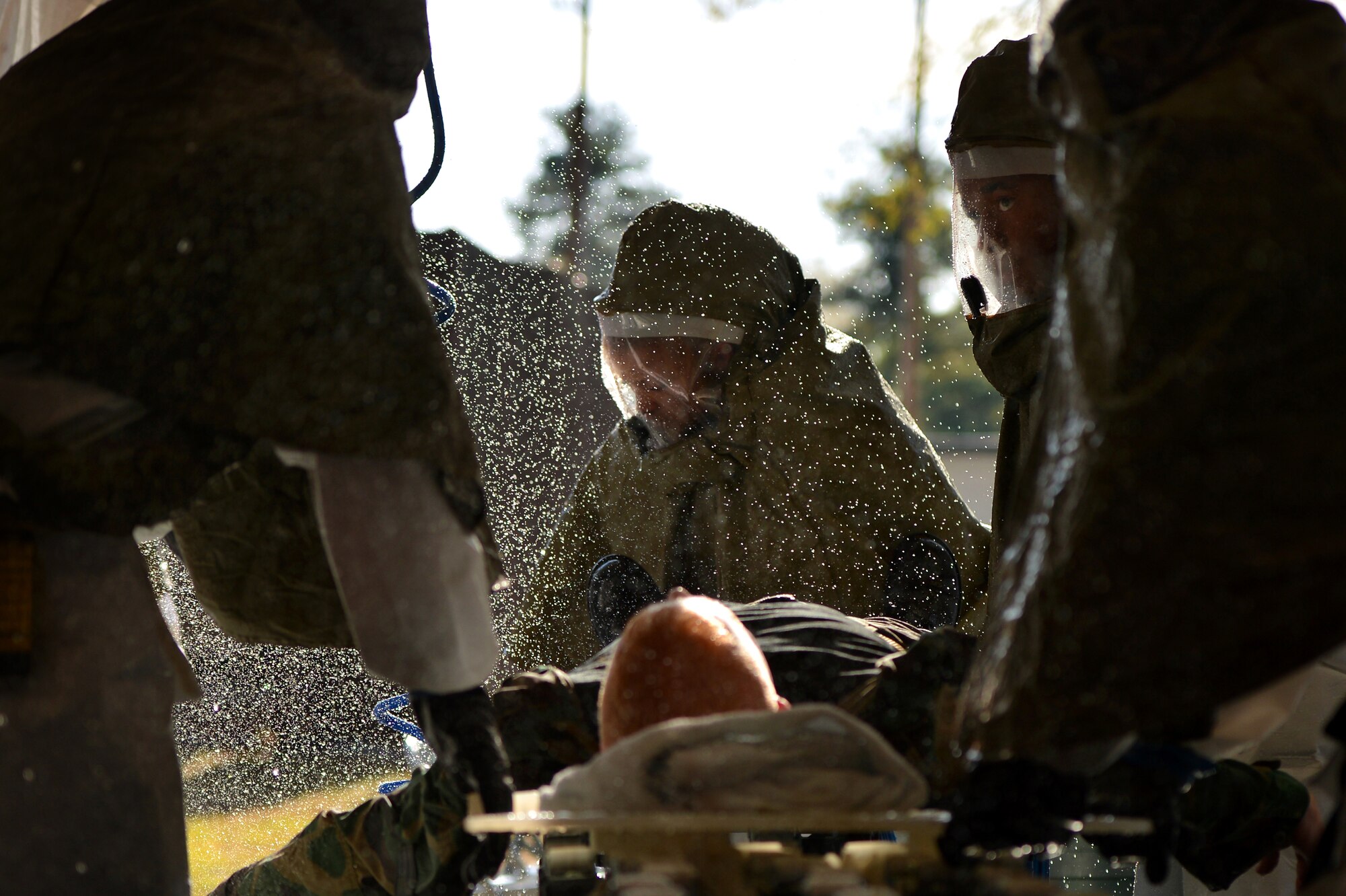 U.S. Air Force Staff Sgt. James Springer, 20th Medical Operations Squadron alcohol, drug, abuse, prevention, and treatment NCO in charge, (center,) is sprayed with water while being decontaminated during a Mass Accident Response Exercise, April 4, 2014, Shaw Air Force Base, S.C. The 20th MDG holds exercises such as these during different times throughout the year to stay trained and prepared for real world situations. (U.S. Air Force photo by Staff Sgt. Kenny Holston/Released)