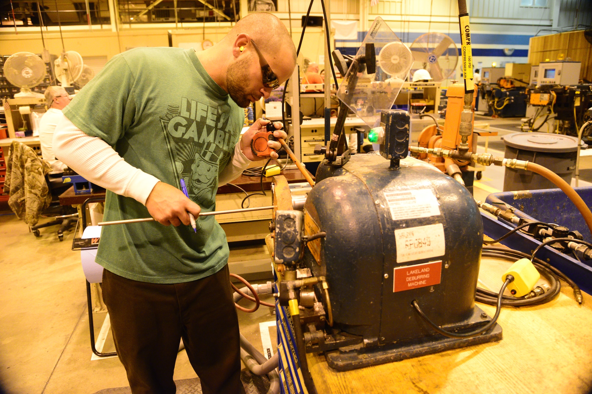 6430 Hal Mickel, 402nd CMXG, uses the DeBarr Machine to smooth the end of a piece of tubing. (U.S. Air Force photo by Ray Crayton)