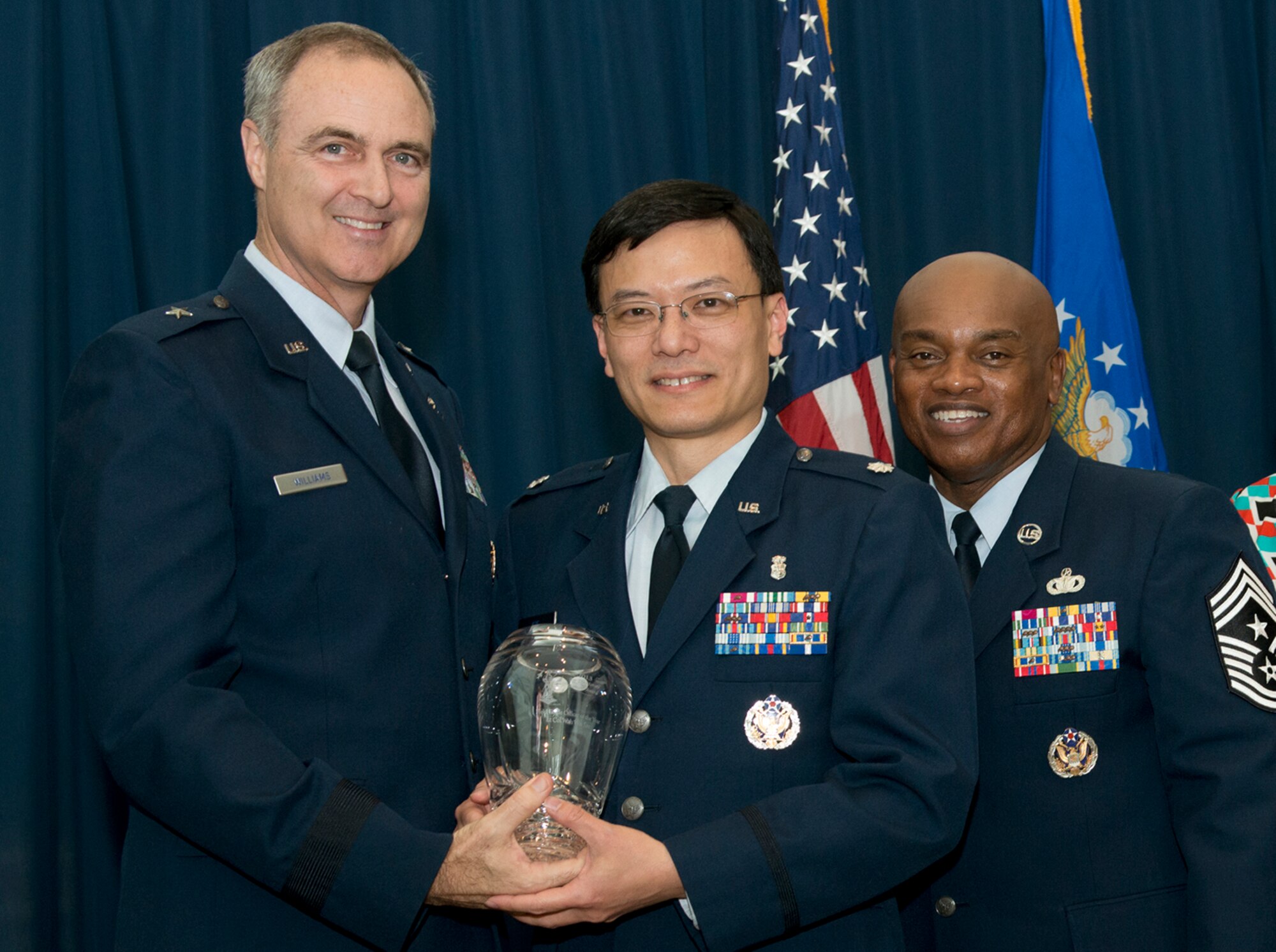 Brig. Gen. R. Scott Williams, the commander of the Air National Guard Readiness Center, and Chief Master Sgt. Tony L. Whitehead, the command chief master sergeant of the ANGRC, present the Field Grade Officer of the Year award to , Lt. Col. Wah Wai Sze, Air Surgeon, during the ANGRC 2013 Annual Awards Ceremony April 4, 2014, at the ANGRC, Joint Base Andrews, Md. The ceremony hosted by Williams recognizes the accomplishments of the ANGRC staff. (U.S. Air National Guard photo by Master Sgt. Marvin R. Preston/RELEASED)