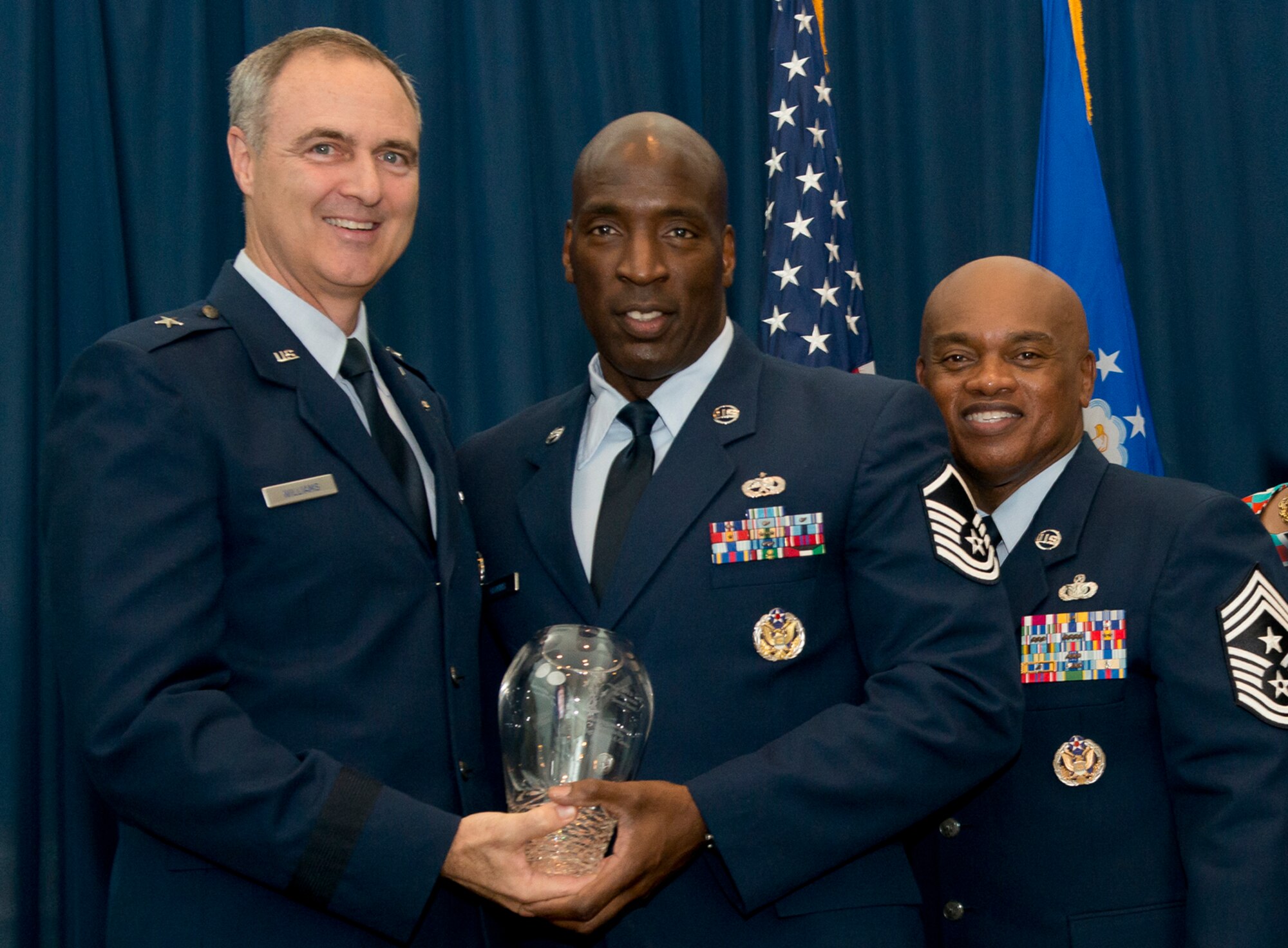 Brig. Gen. R. Scott Williams, the commander of the Air National Guard Readiness Center, and Chief Master Sgt. Tony L. Whitehead, the command chief master sergeant of the ANGRC, present the Senior Non-Commissioned Officer of the Year award to Master Sgt. Kenneth A. Gowins, Communications, during the ANGRC 2013 Annual Awards Ceremony April 4, 2014, at the ANGRC, Joint Base Andrews, Md. The ceremony hosted by Williams recognizes the accomplishments of the ANGRC staff. (U.S. Air National Guard photo by Master Sgt. Marvin R. Preston/RELEASED)