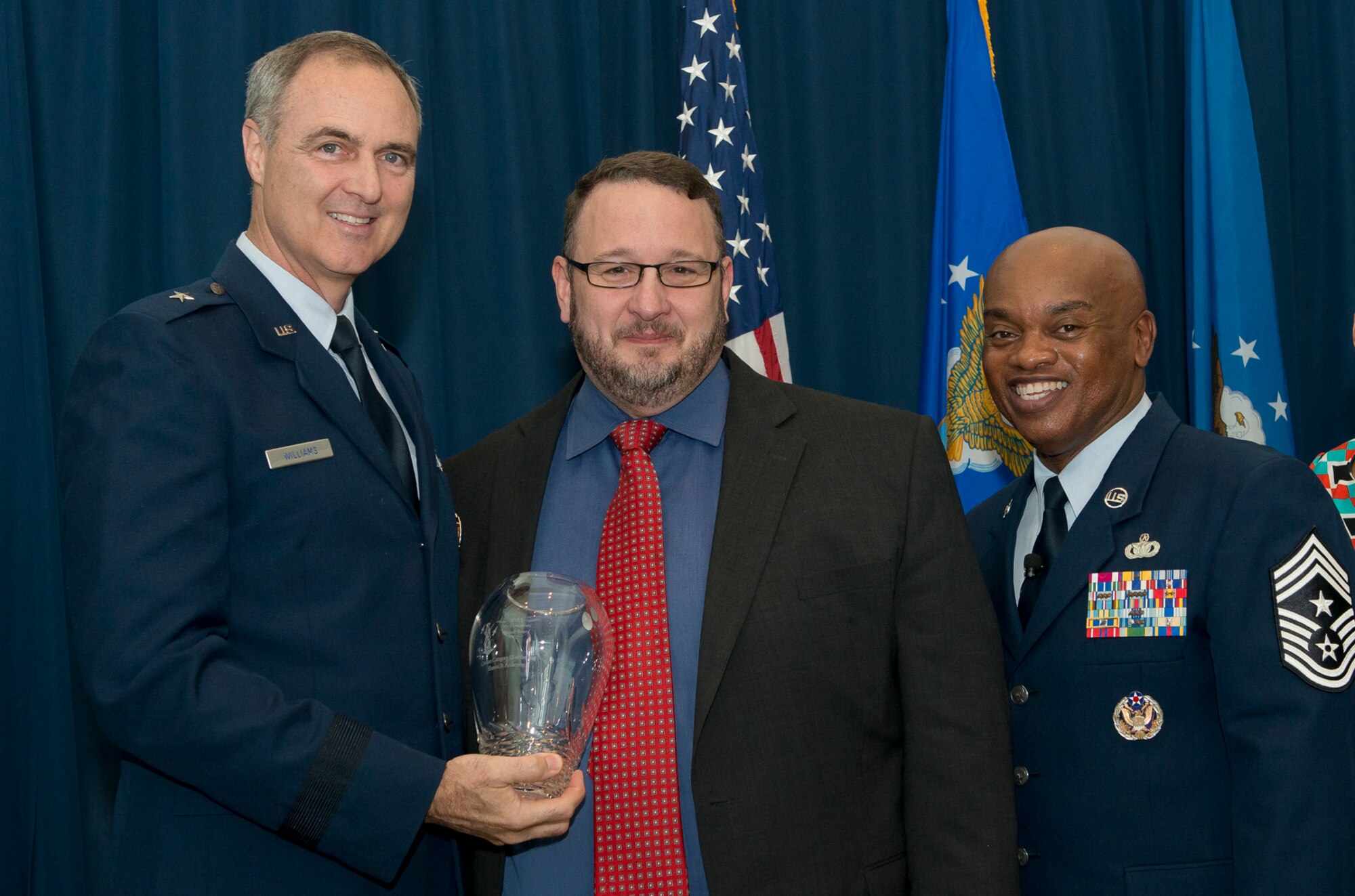 Brig. Gen. R. Scott Williams, the commander of the Air National Guard Readiness Center, and Chief Master Sgt. Tony L. Whitehead, the command chief master sergeant of the ANGRC, present the Civilian of the Year Category 3 award to Shawn B. Anderson, Communications, during the ANGRC 2013 Annual Awards Ceremony April 4, 2014, at the ANGRC, Joint Base Andrews, Md. The ceremony hosted by Williams recognizes the accomplishments of the ANGRC staff. (U.S. Air National Guard photo by Master Sgt. Marvin R. Preston/RELEASED)