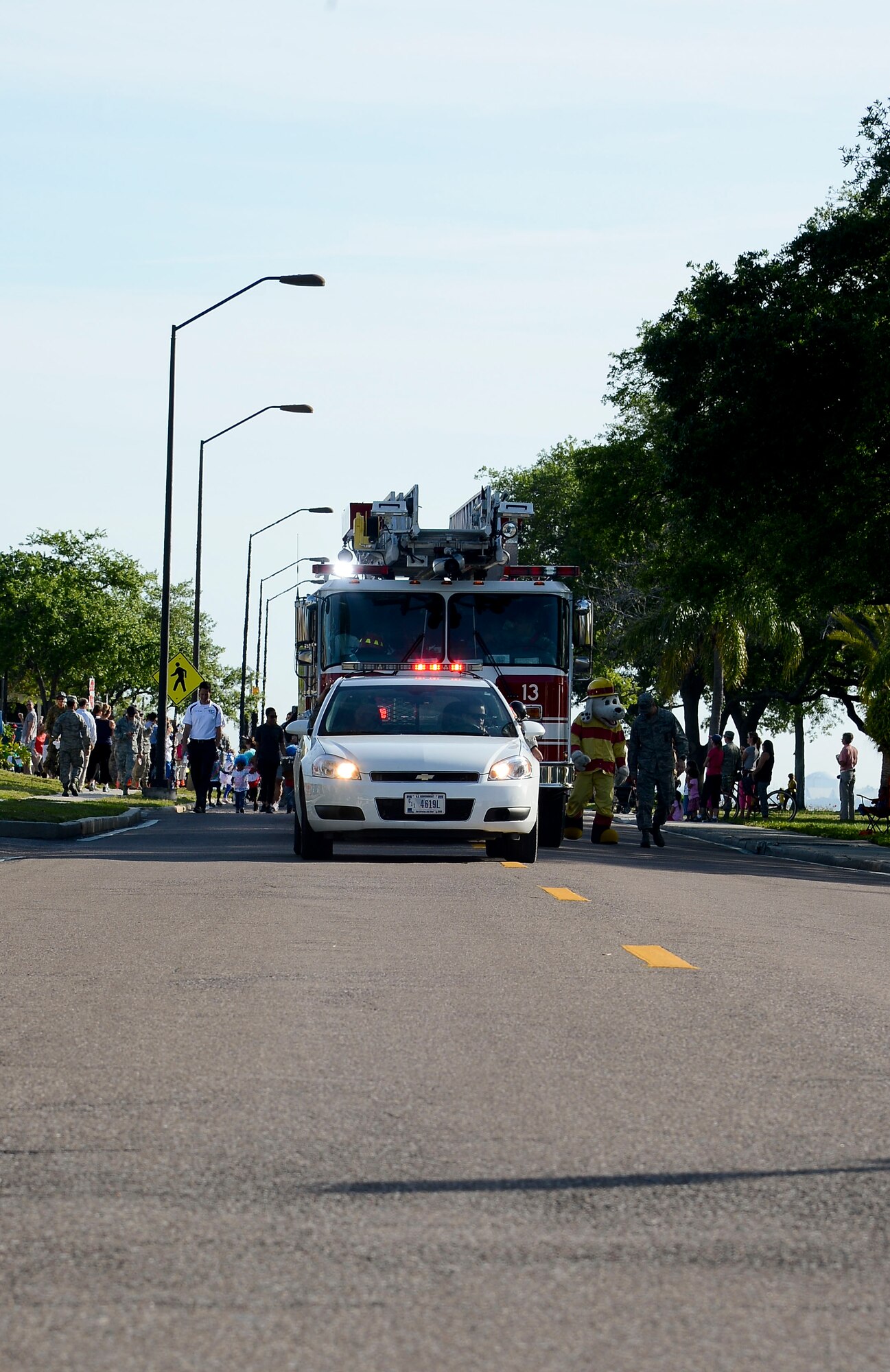 A police vehicle and fire truck lead the Month of the Military Child parade April 3, 2014 at MacDill Air Force Base, Fla. The parade featured members of the base honor guard, a drum line, Sparky the fire department mascot, and floats made by the staff of the Child Development Centers. (U.S. Air Force photo by Senior Airman Jenay Randolph/Released)