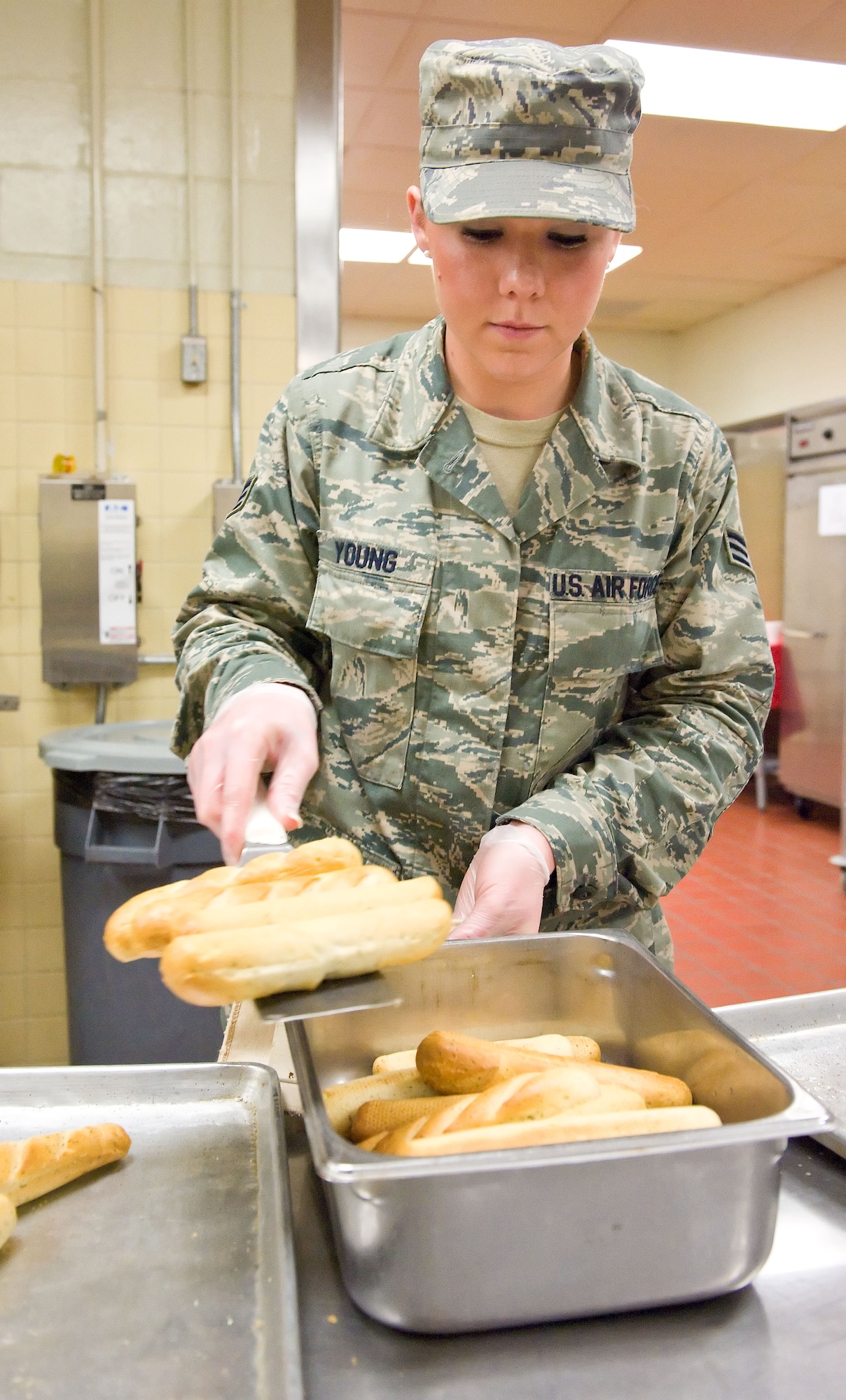 Senior Airman Katie Young, 436th Force Support Squadron food service apprentice, places bread sticks in a serving tray March 28, 2014, at the Patterson Dining Facility on Dover Air Force Base, Del. Young prepared over 100 bread sticks for the pasta bar. (U.S. Air Force photo/Roland Balik)
