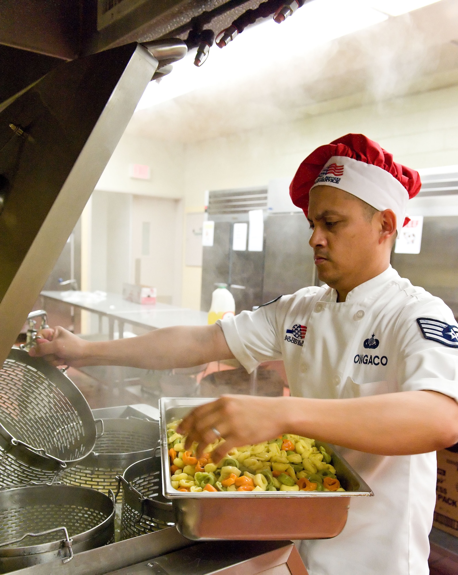 Staff Sgt. Rommel Ongaco, 436th Force Support Squadron food service supervisor, removes tri-colored tortellini from a pasta cooker March 28, 2014, at the Patterson Dining Facility on Dover Air Force Base, Del. Ongaco prepared the tortellini for the pasta bar. (U.S. Air Force photo/Roland Balik)