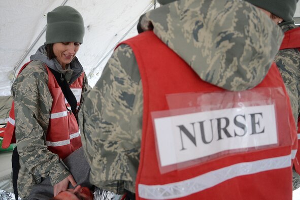 NAVAL STATION NEWPORT, R.I. – U.S. Air Force Capt. Tori Scearbo, 157th Medical Group nurse, treats a patient alongside other medical staff during a maritime exercise intended to conduct mass medical care and triage to patients March 29 at the Naval Station Newport. Members of the New England Chemical, Biological, Radiological, Nuclear and High-Yield Explosives team, or CERFP team, conducted a full scale exercise in order to increase readiness posture and facilitate improved catastrophic responses with multi-agency partners. The exercise also was intended to test the team’s ability to run maritime operations. (N.H. Air National Guard photo by Tech. Sgt. Mark Wyatt/RELEASED)

