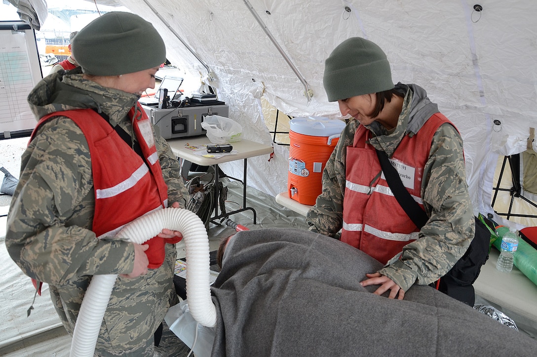 NAVAL STATION NEWPORT, R.I. – U.S. Air Force Capt. Tori Scearbo and 1st Lt. Lindsey Paciello, both 157th Medical Group nurses, treat a patient during a maritime mass medical emergency exercise March 29 at the Naval Station Newport. Members of the New England Chemical, Biological, Radiological, Nuclear and High-Yield Explosives team, or CERFP team, conducted a full scale exercise in order to increase readiness posture and facilitate improved catastrophic responses with multi-agency partners. The exercise also was intended to test the team’s ability to run maritime operations. (N.H. Air National Guard photo by Tech. Sgt. Mark Wyatt/RELEASED)
