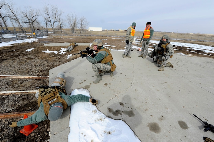 Airman 1st Class Justin Eisinger, 341st Security Forces Group Tactical Response Force assaulter (left), and Senior Airman Michael Piela, 341st SFG TRF assaulter (center), simulate recapturing a missile launch facility while being observed by their teammates during a training session at the Warrior Launch Facility trainer March 25. According to participants, the simulation is one of many training sessions which take place to ensure Malmstrom’s TRF teams’ specified skill sets are honed and ready to be put into action at a moment’s notice. (U.S. Air Force photo/Airman 1st Class Collin Schmidt)