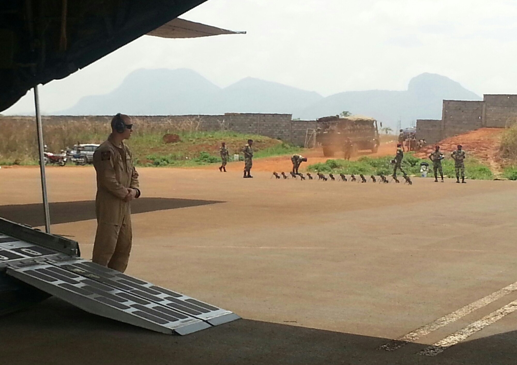 U.S. Air Force Senior Airman Gregg Haynes, assigned to the 139th Security Forces Squadron, Missouri Air National Guard, stands next to a C-130 Hercules cargo aircraft in central Africa during March 2014. Haynes was trained as a Phoenix Raven to provide security to the aircraft and crew during Exercise Flintlock and Exercise Central Accord. (U.S. Air National Guard photo by Tech. Sgt. Chris Black/Released)