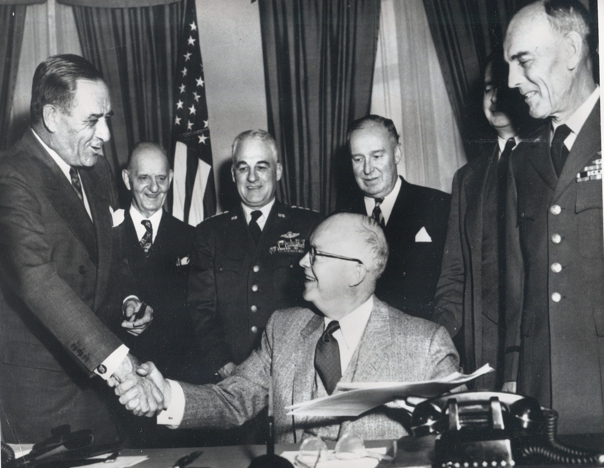 President Dwight D. Eisenhower (seated) shakes hands with Secretary of the Air Force Harold E. Talbott April 1, 1954, after signing legislation authorizing the establishment of the U.S. Air Force Academy. Looking on (from left) are Congressman Karl Vinton, of Georgia; Gen. Nathan F. Twining, Air Force chief of staff; Congressman Dewey Short, chairman of the House Armed Services Committee; James H. Douglas, undersecretary of the Air Force, and Lt. Gen. Hubert R. Harmon, special assistant for the Academy. (U.S. Air Force Academy McDermott Library Archives)
